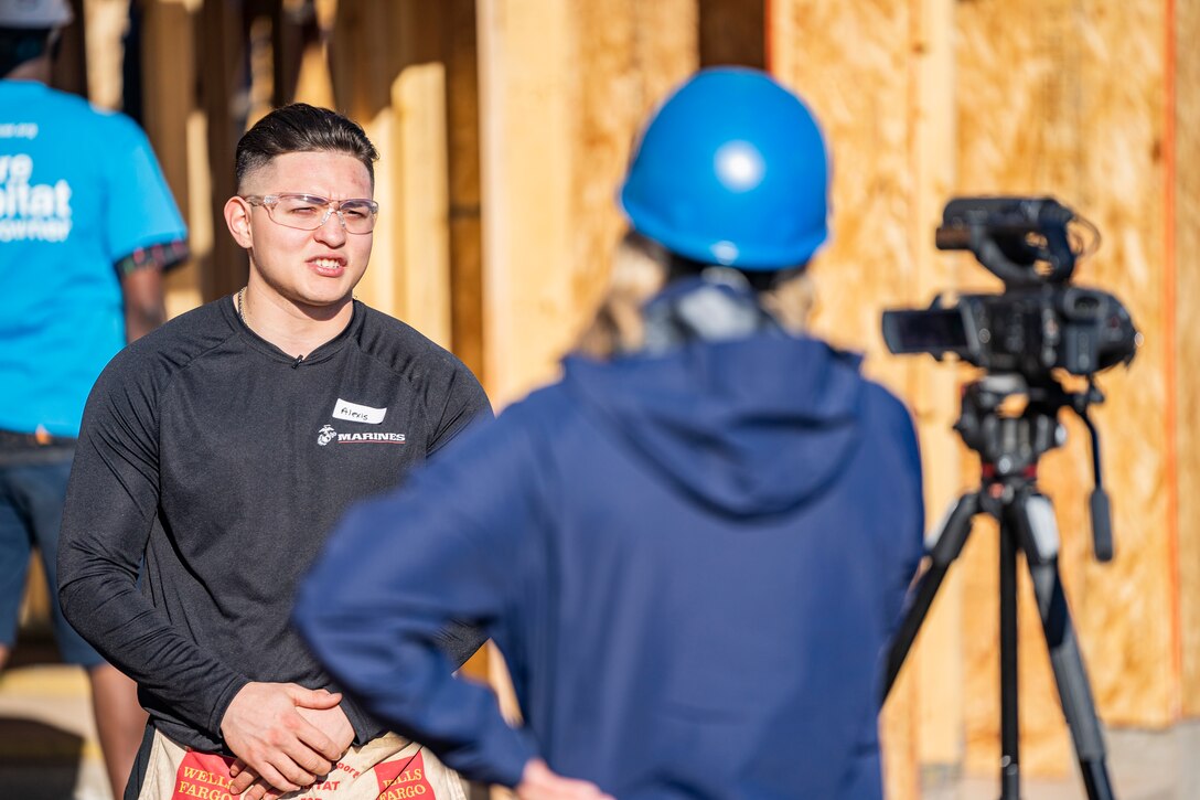 A poolee from Recruiting Substation Arrowhead conducts an interview with the local media on Dec. 11, 2021 in Phoenix, Arizona. The Marines and poolees assisted Habitat for Humanity to help out those less fortunate in the local community before the Holidays. (U.S. Marine Corps photo by Cpl. Brennan J. Beauton)