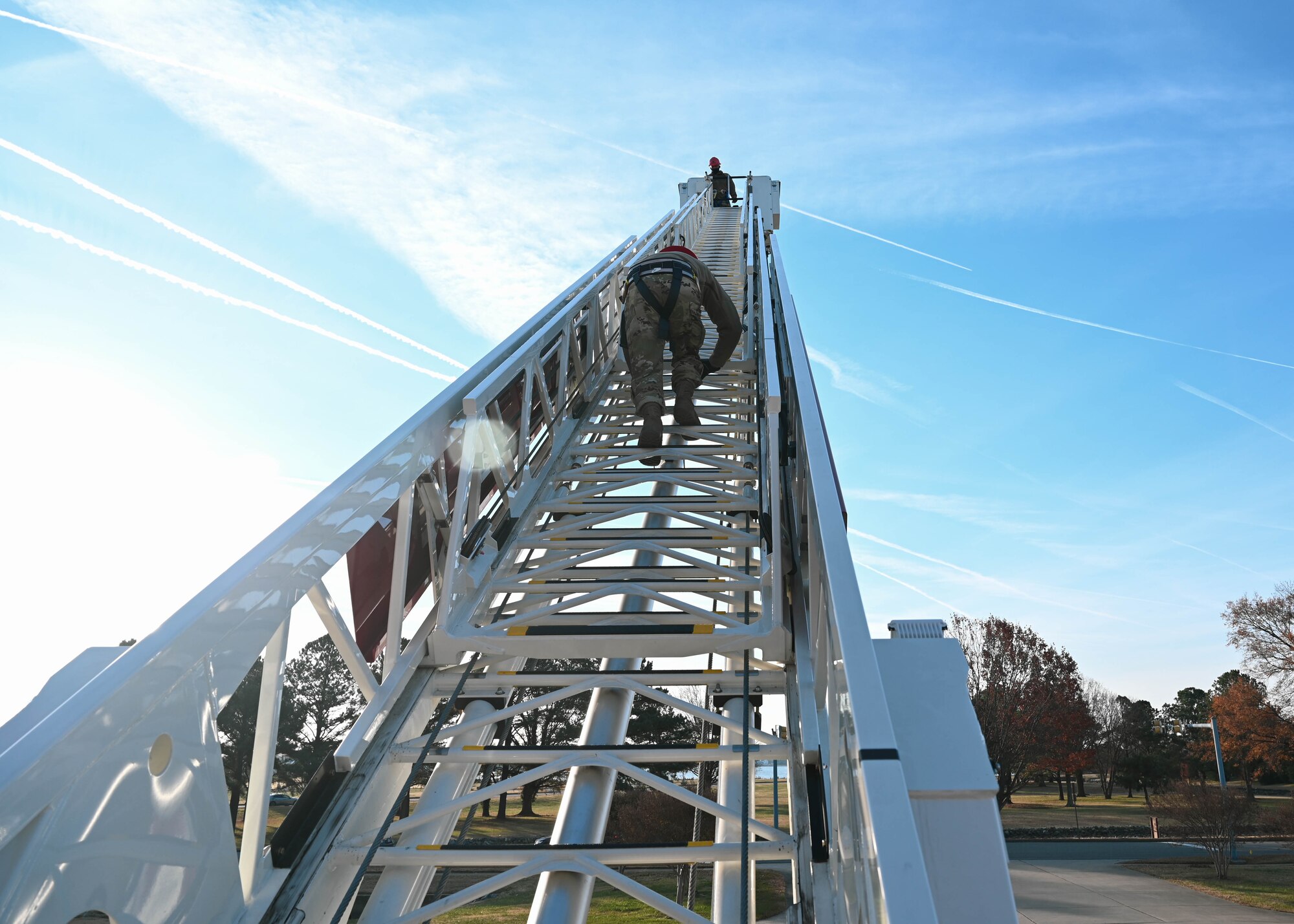 U.S. Air Force Airman 1st Class Christopher Parks, 633d Civil Engineer Squadron firefighter, climbs the Langley Fire Department’s new aerial ladder fire truck at Joint Base Langley-Eustis, Virginia, Dec. 10, 2021.