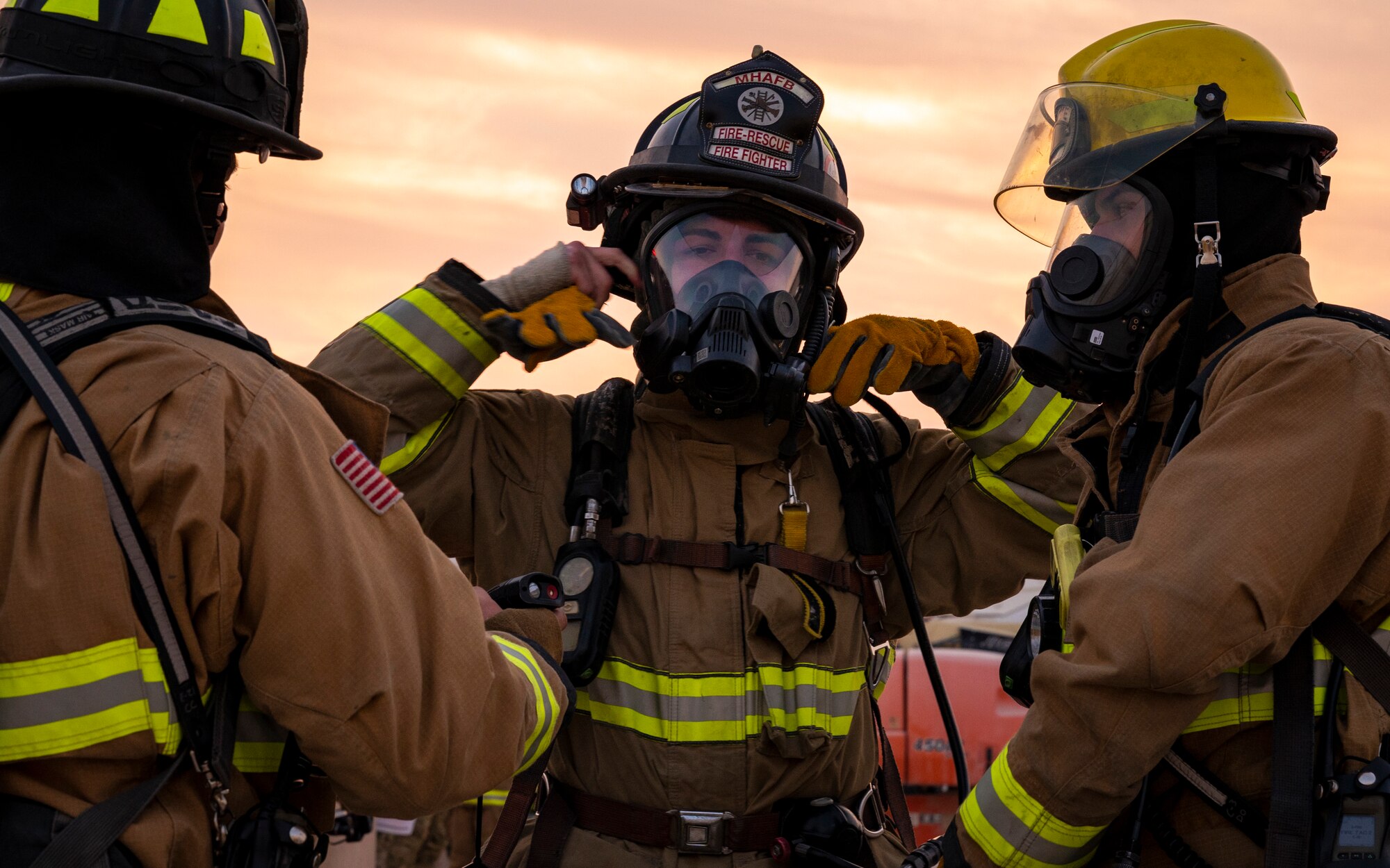 Firefighters put on protective gear.
