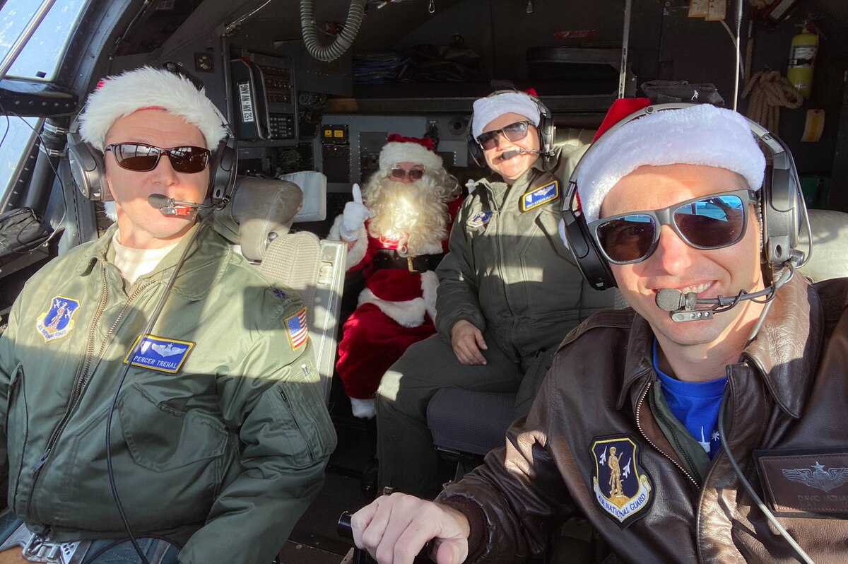 An aircrew from the 192nd Airlift Squadron, Nevada Air National Guard, pose for a photo with Santa Claus in the flight deck of their C-130 Hercules aircraft, Dec. 18, 2021. Mr. Claus visited the Nevada Air National Guard Base to spread holiday greetings and cheer with Nevada Air and Army National Guard members and their families. (U.S. Air National Guard courtesy photo)