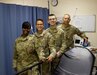 Tech. Sgt. Kenetha Harris, Capt. William Waling, Senior Airman Tyler Begg and Master Sgt. Jason Kluttz stand in a treatment room at the medical clinic at Al Dhafra Air Base, United Arab Emirates, Dec. 13, 2021. All four Airmen are members of the 127th Medical Group, 127th Wing, Michigan Air National Guard and are forward deployed from Selfridge Air National Guard Base, Michigan. (U.S. Air Force photo by Master Sgt. Dan Heaton)