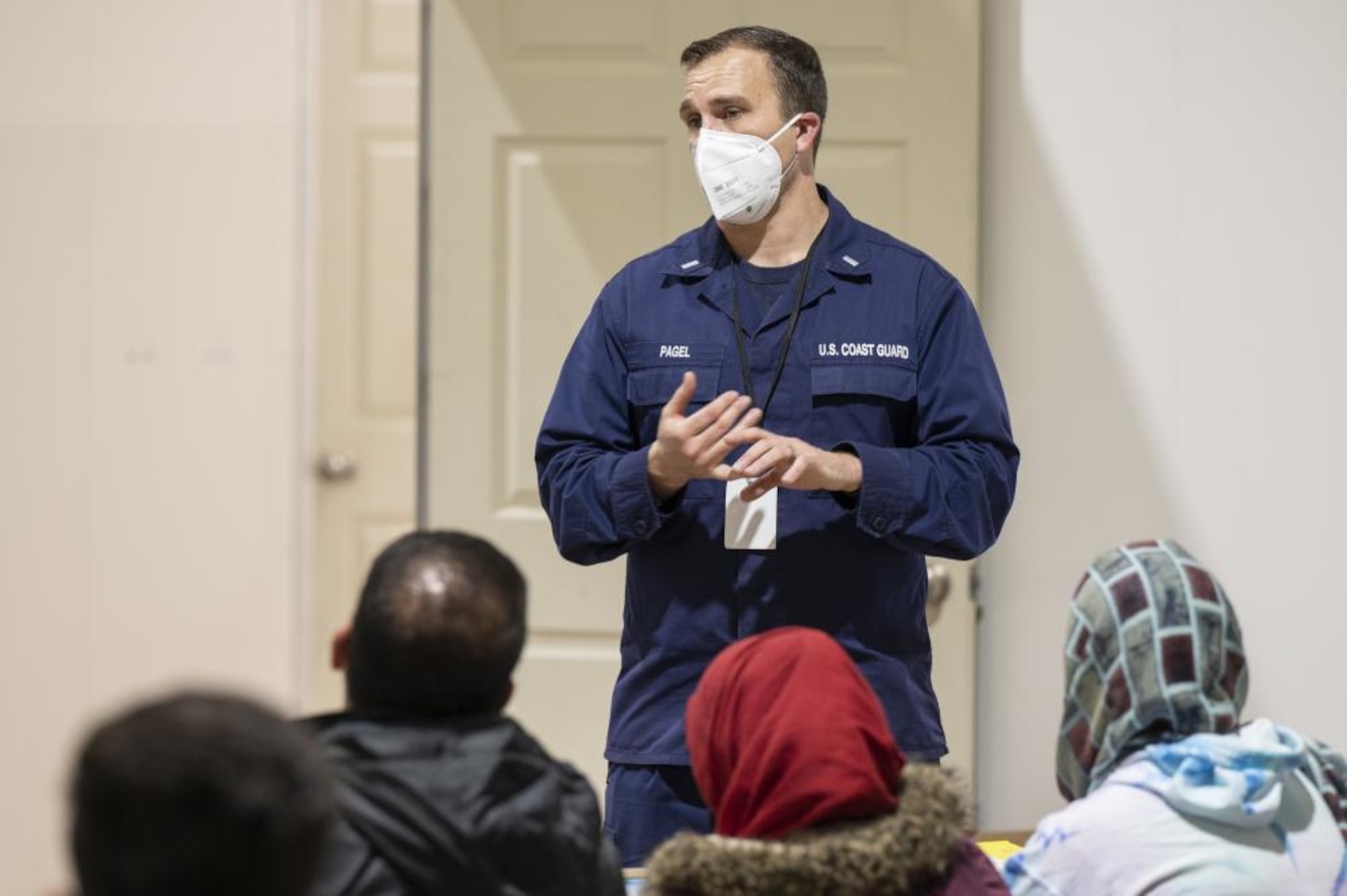 U.S. Coast Guard Lt. j.g. Todd Pagel, Task Force Liberty education director, briefs Afghan guests during teacher orientation in Liberty Village, Joint Base McGuire-Dix-Lakehurst, New Jersey, Dec. 16, 2021. The Department of Defense, through U.S. Northern Command, and in support of the Department of Homeland Security, is providing transportation, temporary housing, medical screening, and general support for at least 11,000 Afghan evacuees at Liberty Village, in permanent or temporary structures, as quickly as possible. This initiative provides Afghan personnel essential support at secure locations outside Afghanistan. (U.S. Air Force photo by Tech. Sgt. Matthew B. Fredericks)