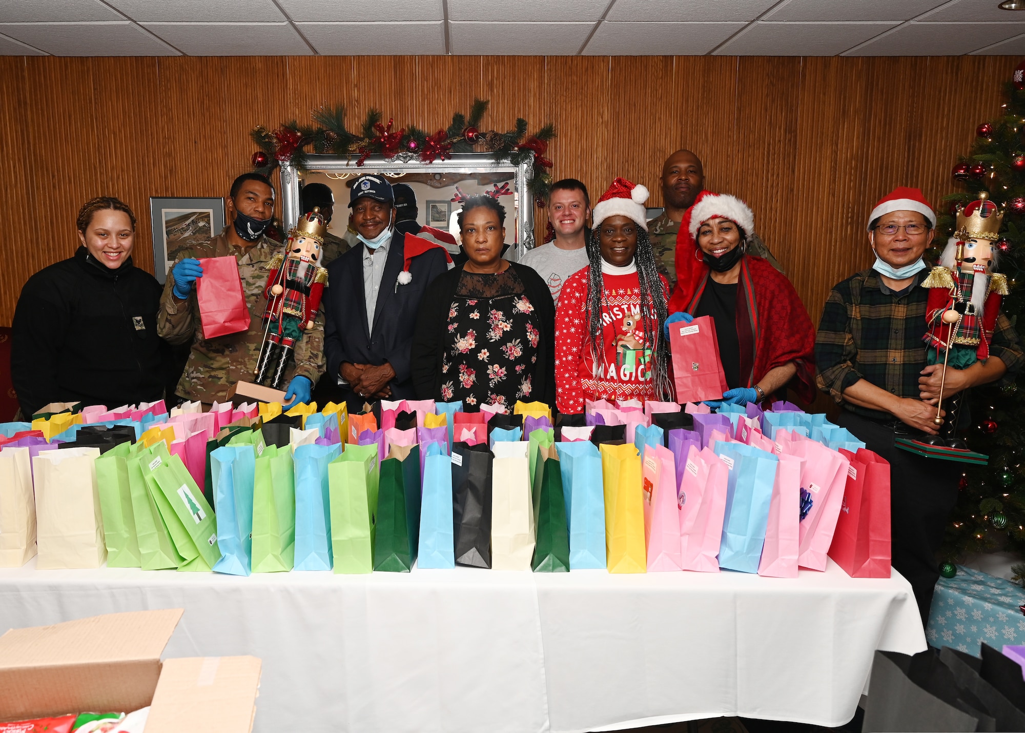 Volunteers for the annual Cookie Caper pose for a photo in the Bolling Club at Joint Base Anacostia-Bolling, Washington, D.C. on Dec. 17, 2021. The Cookie Caper is an annual charitable holiday event led by the base housing staff that has allowed for the collection and distribution of more than 80 thousand cookies to unaccompanied military members in the JBAB dormitories since 2010. (U.S. Air Force photo by Staff Sgt. Kayla White)