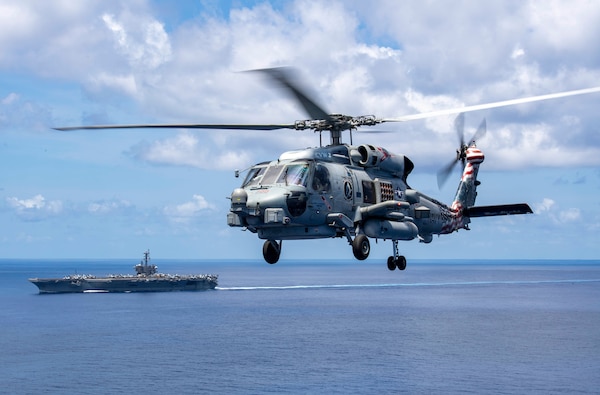 211217-N-HH215-1320 INDIAN OCEAN (Dec. 17, 2021) An MH-60R Sea Hawk, assigned to the “Blue Hawks” of Helicopter Maritime Strike Squadron (HSM) 78 transits alongside Nimitz-class aircraft carrier USS Carl Vinson (CVN 70) during a bilateral training exercise with the Royal Australian Air Force, Dec. 17, 2021. Carl Vinson Carrier Strike Group and elements of the Royal Australian Navy and Air Force are conducting a bilateral training exercise to test and refine warfighting capabilities in support of a free and open Indo-Pacific. (U.S. Navy photo by Mass Communication Specialist 1st Class Tyler R. Fraser)