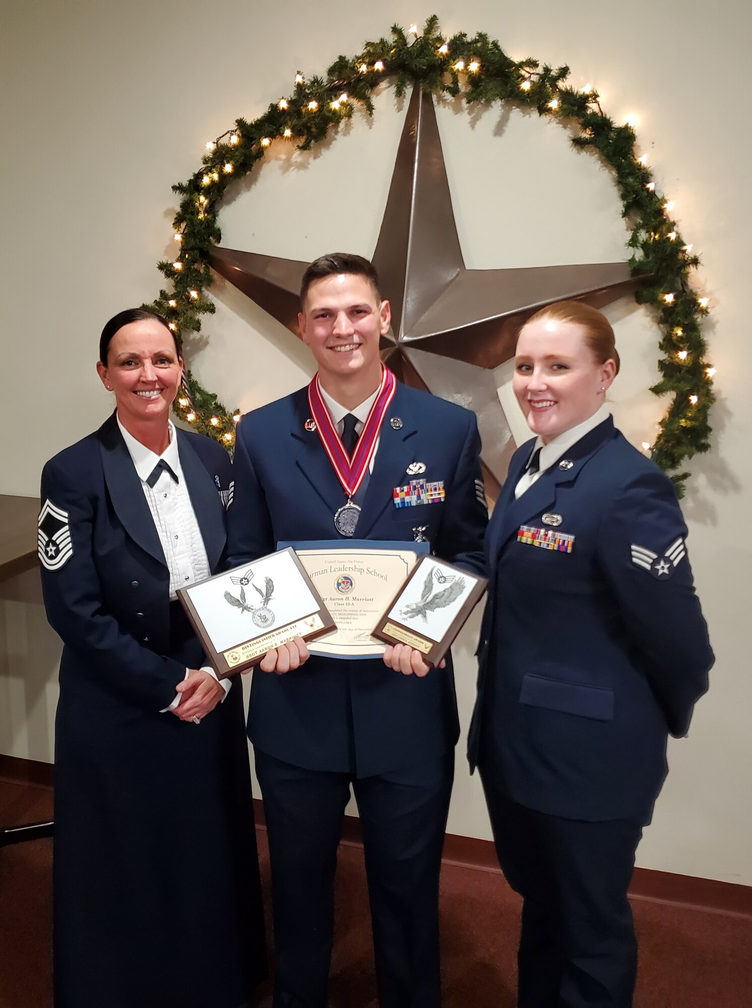 Staff Sgt. Aaron Marriott, 7th Civil Engineer Squadron firefighter, center, poses with his Airman Leadership School awards with his mother Senior Master Sgt. Daneen Jeziorske, the Air Force Global Strike Command command mental health functional manager , left, and sister Senior Airman Caitlyn Jeziorske, 7th Component Maintenance Squadron command support staff, right, at Dyess Air Force Base, Texas, Dec. 9, 2021.