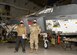 Airmen pose for a photo in front of the F-22 aircraft they are rebuilding.