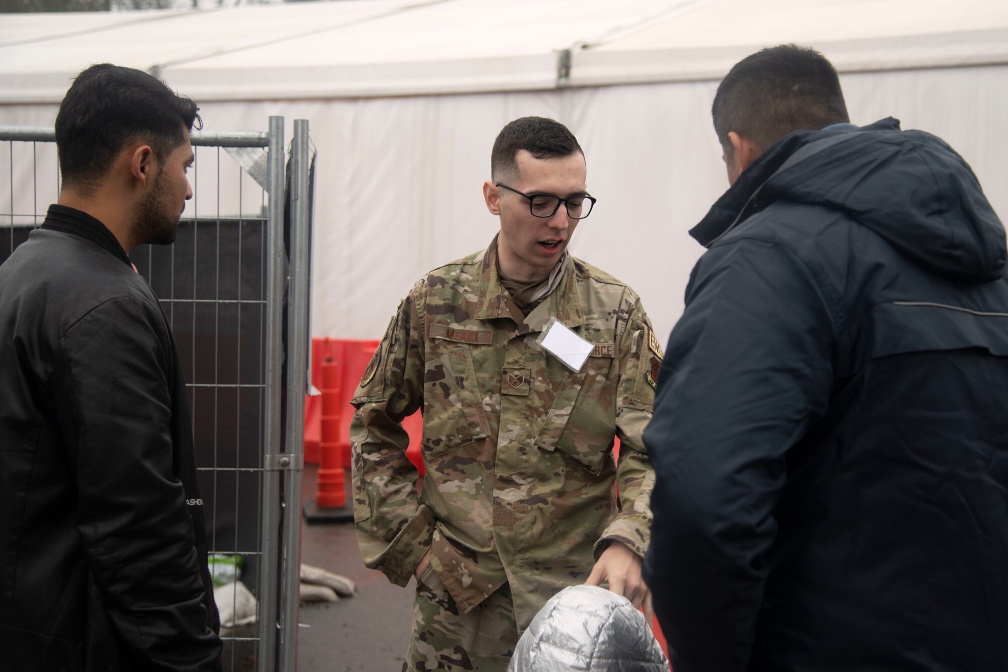 Staff Sgt. Sam Meaux, a member with Task Force Liberty assists guests and guides them to where they can restock on essential supplies in Task Force Liberty Village on Joint Base McGuire-Dix-Lakehurst, New Jersey, December 11, 2021.