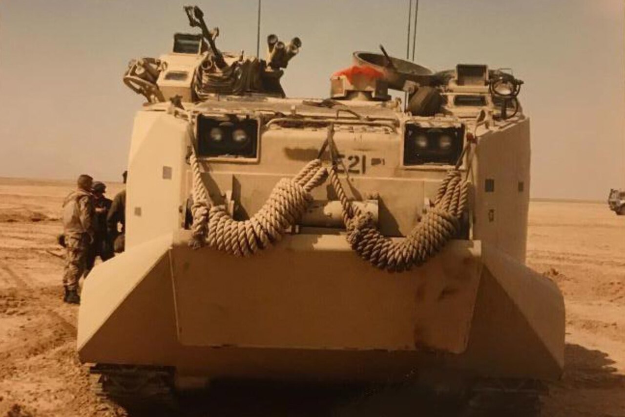 A military vehicle sits motionless in the desert.