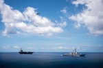 INDIAN OCEAN (Dec. 17, 2021) U.S. Arleigh Burke-class guided-missile destroyer USS Stockdale (DDG 106) and U.S. Nimitz-class aircraft carrier USS Carl Vinson (CVN 70) transit the Indian Ocean while two Royal Australian Air Force P-8A Poseidons, assigned to 11 Squadron, fly overhead during a bilateral training exercise Dec. 17, 2021. Carl Vinson Carrier Strike Group and elements of the Royal Australian Navy and Air Force are conducting a bilateral training exercise to test and refine warfighting capabilities in support of a free and open Indo-Pacific. (U.S. Navy photo by Mass Communication Specialist 2nd Class Haydn N. Smith)