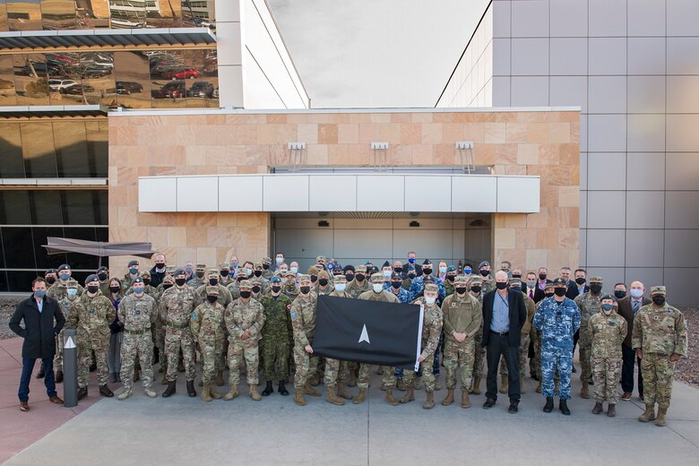 Participants of SPACE FLAG 22-1 pose for a group photo on Dec. 6, 2021 at Schriever Space Force Base, Colorado.   This was the first SPACE FLAG at Schriever Space Force Base, and was the first SPACE FLAG to offer a realistic combat simulation for coalition space warfighters. (U.S. Space Force photo by Judi Tomich)