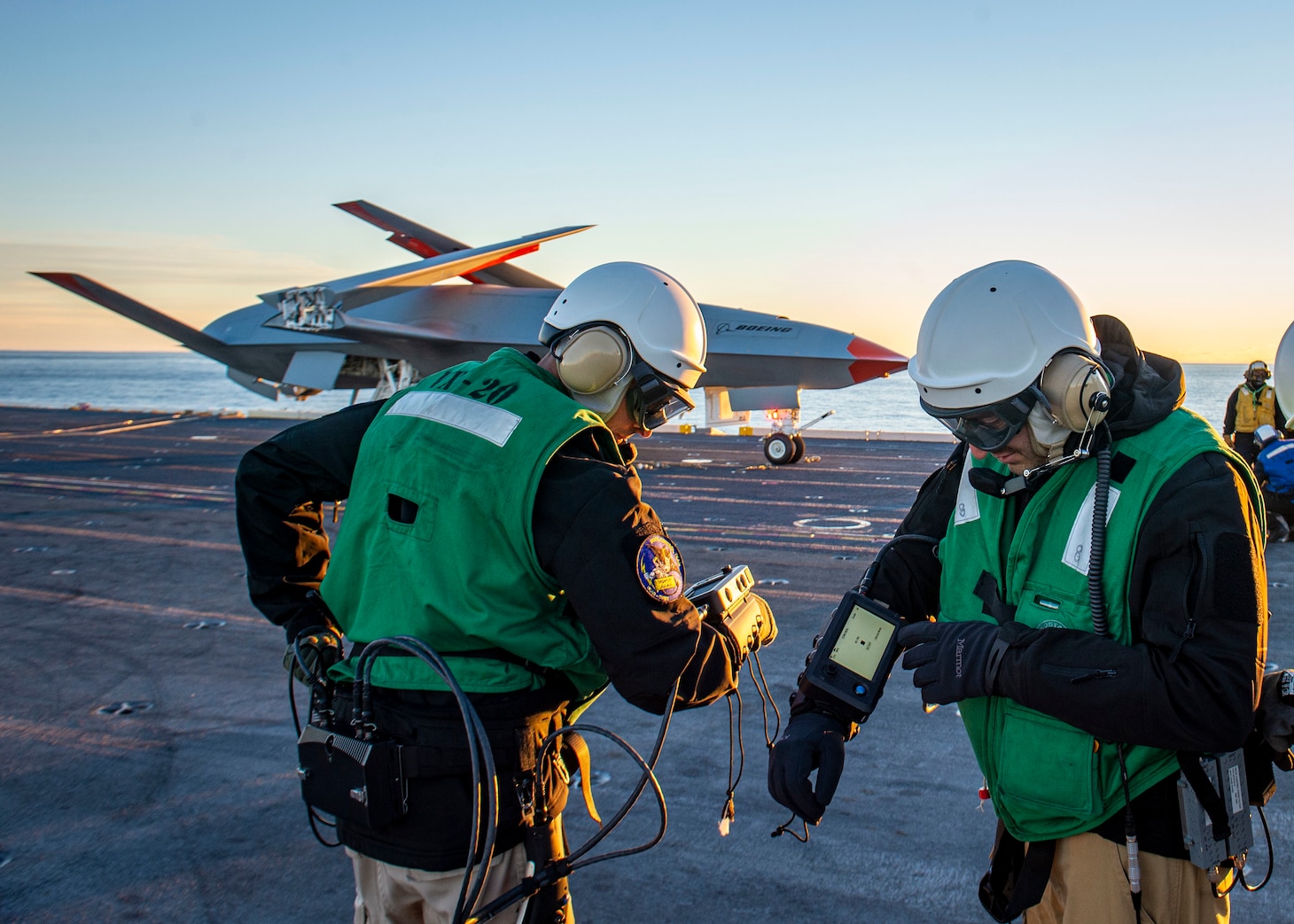 Boeing employees run diagnostics on the Boeing unmanned MQ-25 aircraft on the flight deck aboard the aircraft carrier USS George H.W. Bush (CVN 77).