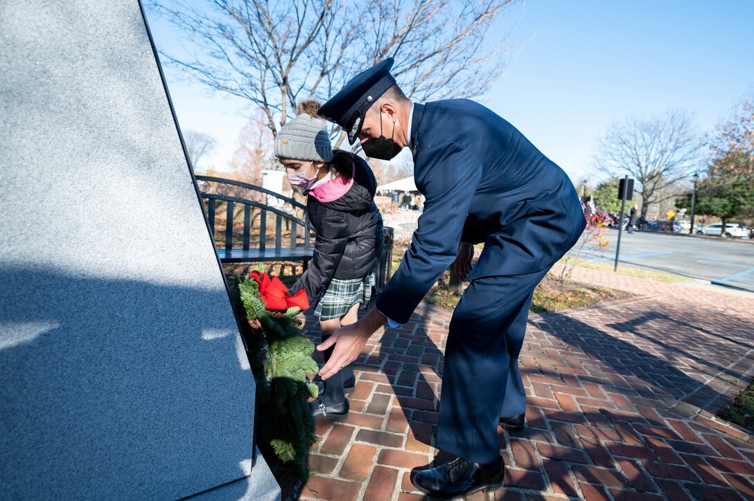 Col. Matt Husemann, 436th Airlift Wing commander, and Lily Cutrona lay a wreath at the Medal of Honor memorial Dec. 13, 2021 in Dover, Delaware. After the ceremony, wreaths were laid at various war memorials in downtown Dover. (U.S. Air Force photo by Mauricio Campino)