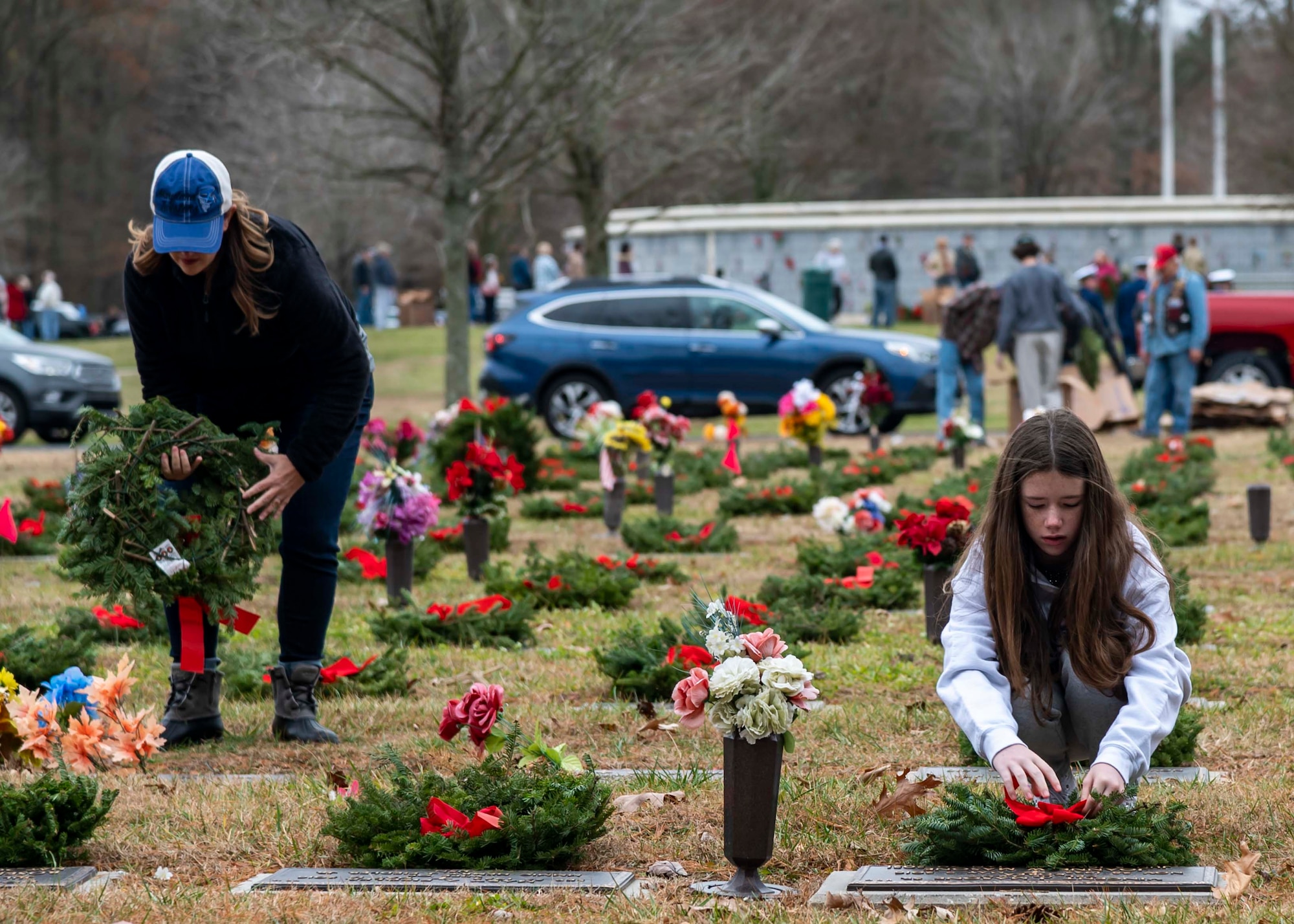 Volunteers lay wreaths on graves at the Delaware Veterans Memorial Cemetery in Millsboro, Delaware, Dec. 18, 2021. Each December, on National Wreaths Across America Day, wreath laying ceremonies are held across the country at more than 2,100 cemeteries, honoring veterans and those who have fallen. (U.S. Air Force photo by Senior Airman Stephani Barge)