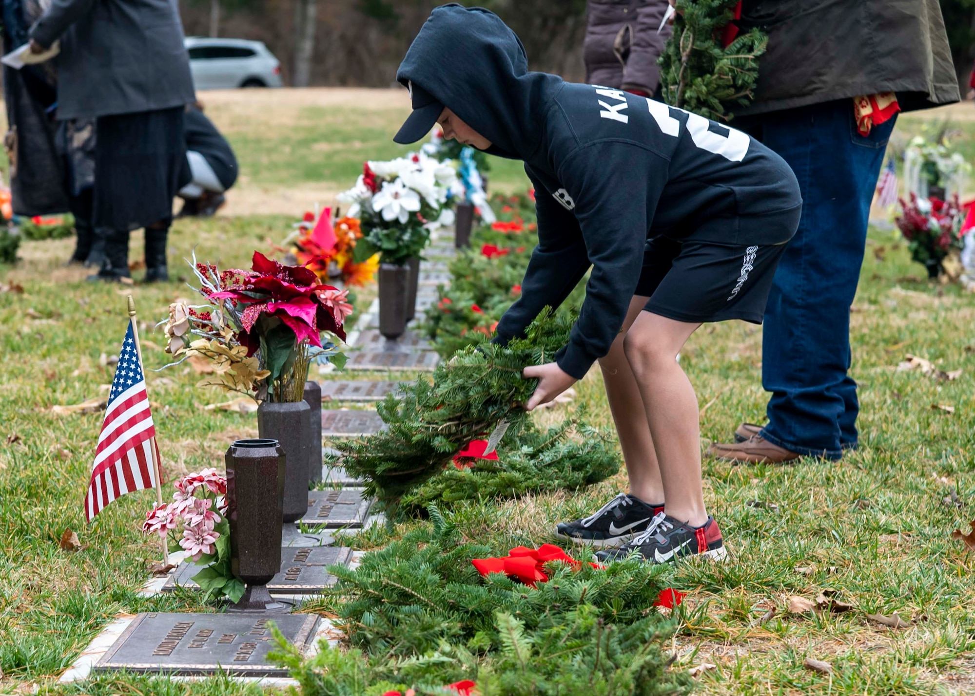 A volunteer places a wreath on a grave at the Delaware Veterans Memorial Cemetery in Millsboro, Delaware, Dec. 18, 2021. Each December, on National Wreaths Across America Day, wreath laying ceremonies are held across the country at more than 2,100 cemeteries, honoring veterans and those who have fallen. (U.S. Air Force photo by Senior Airman Stephani Barge)