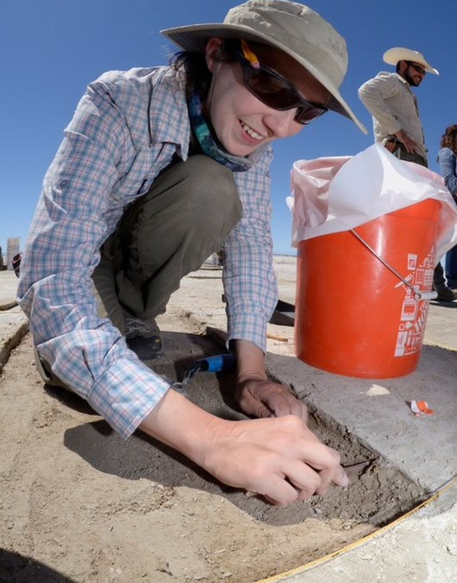 staff archaeologist Lindsey Daub digging at a site