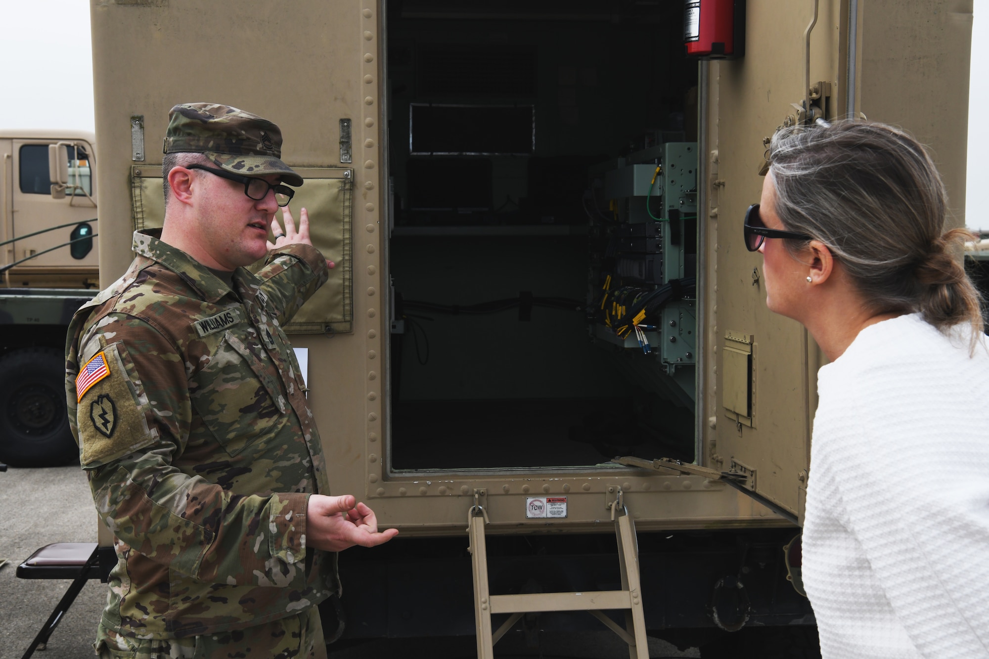 U.S Army Sgt. First Class Timothy Williams, a platoon sgt. assigned to the 371st Sustainment Brigade, explains the capabilities of a mobile communications terminal to Pamela Rigling, senior business advisor for The Greentree Group., dur the 178th Wing's Community Day Sept. 16, 2021 in Springfield, Ohio. The event enhanced awareness of the missions and capabilites of the wing. (U.S. Air National Guard photo by Shane Hughes)