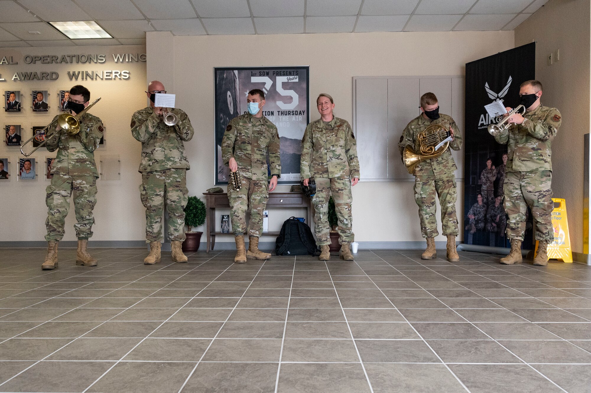 The U.S. Air Force Band of the West plays holiday songs with U.S. Air Force Col. Jocelyn Schermerhorn, 1st Special Operations Wing commander, during a caroling tour