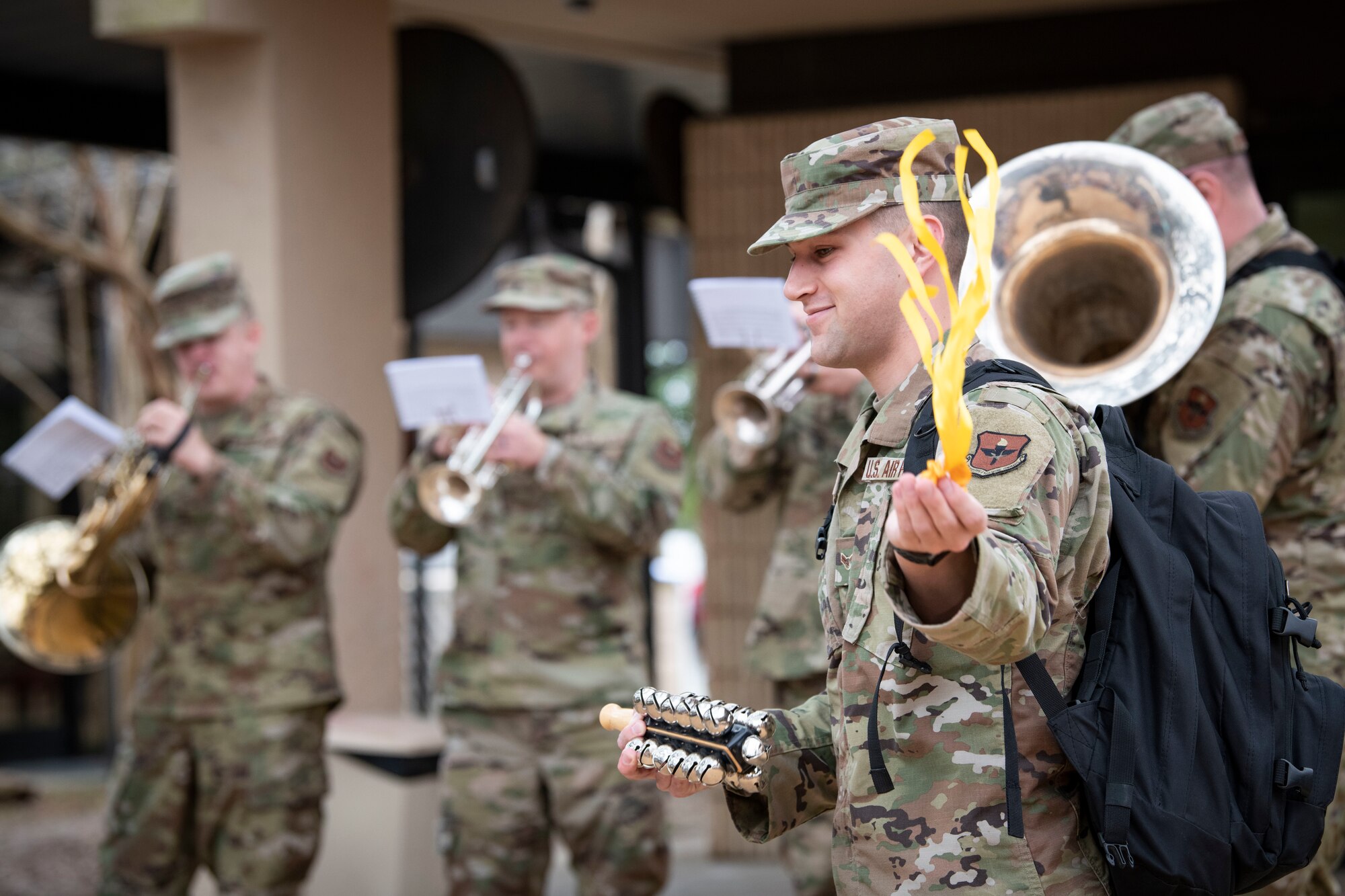 U.S. Air Force Airman 1st Class Austin Pierce, U.S. Air Force Band of the West percussionist, waves a streamer with children at the child development center during a caroling tour