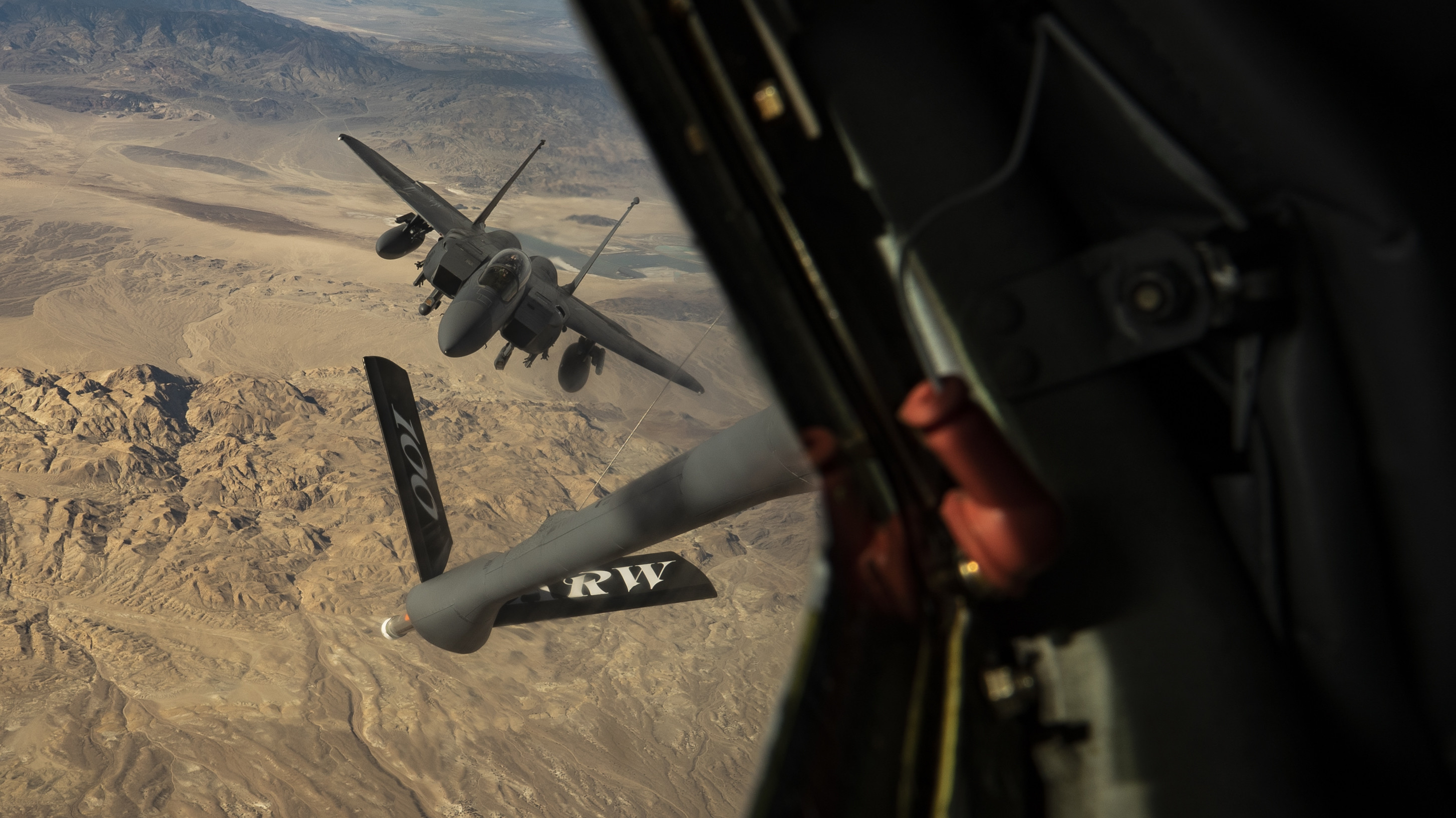 An F-15 from the 433rd Weapons Squadron approaches a KC-135 Stratotanker from the 509th Weapons Squadron to refuel during Weapons School Integration over the Nevada Test and Training Range Dec. 8, 2021. WSINT is a capstone exercise during the Weapons Instructor Course where undergraduates integrate in defensive counter air sorties.