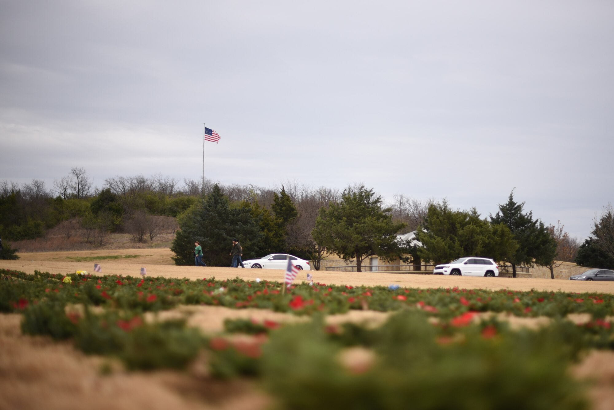 The U.S. flag flies over the Dallas-Fort Worth National Cemetery on Dec. 18, 2021. Volunteers from the DFW community joined together to honor veterans during the Wreaths Across America event. (U.S. Air Force photo by Staff Sgt. Randall Moose)