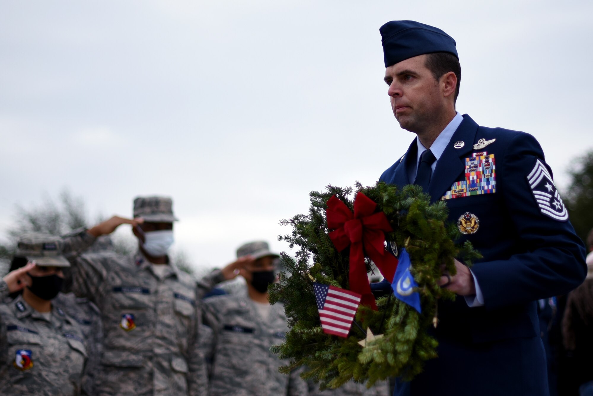 301st Fighter Wing Command Chief Master Sgt. Michael Senigo carries the Air Force wreath during a Wreaths Across America event at the Dallas-Fort Worth National Cemetery on Dec. 18, 2021. Senigo and representatives from each branch laid their respective wreaths to honor their service men and women. (U.S. Air Force photo by Staff Sgt. Randall Moose)