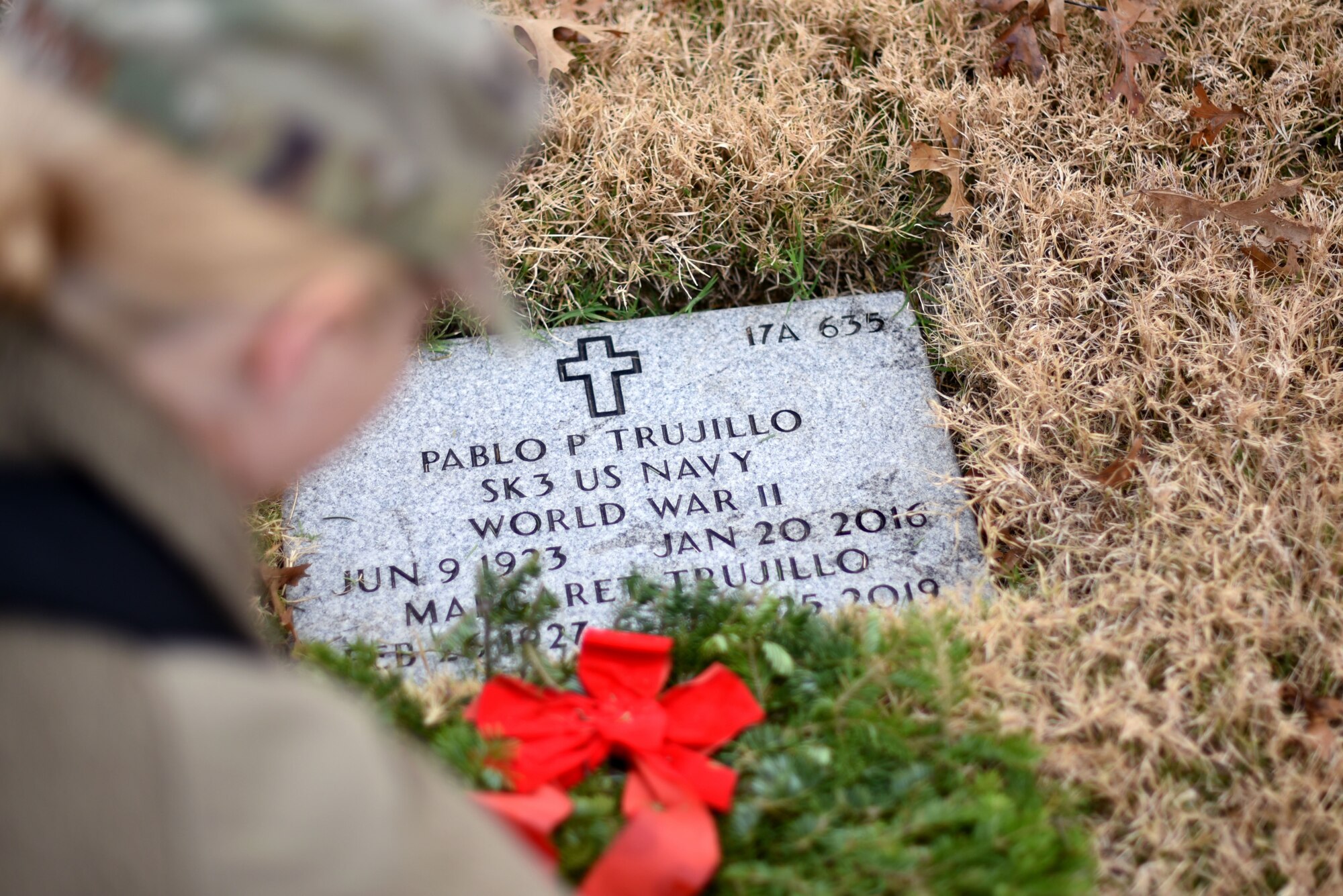 Capt. Jessica Gross, 301st Fighter Wing public affairs officer, places a wreath for Storekeeper Third Class Pablo Trujillo during a Wreaths Across America event at the Dallas-Fort Worth National Cemetery on Dec. 18, 2021. Wreath Across America encourages anyone to participate and honor veterans. (U.S. Air Force photo by Staff Sgt. Randall Moose)