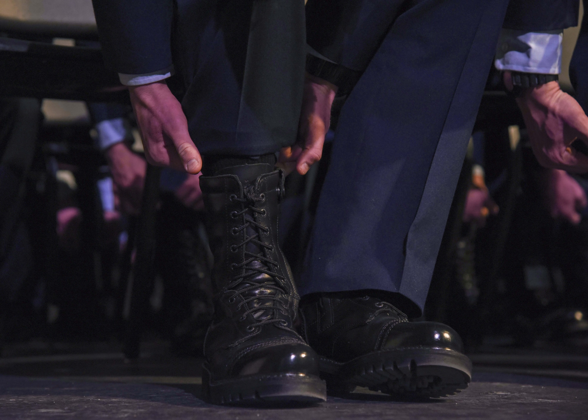 U.S. Air Force Survival Evasion Resistance Escape School graduates ceremonial blouse their boots as part of their ceremony, in Spokane, Washington Dec. 17, 2021. The 336th Training Group held a graduation ceremony for its largest SERE Specialist Apprentice Course with an all-time high of 44 graduates. (U.S. Air Force photo by Airman 1st Class Anneliese Kaiser)