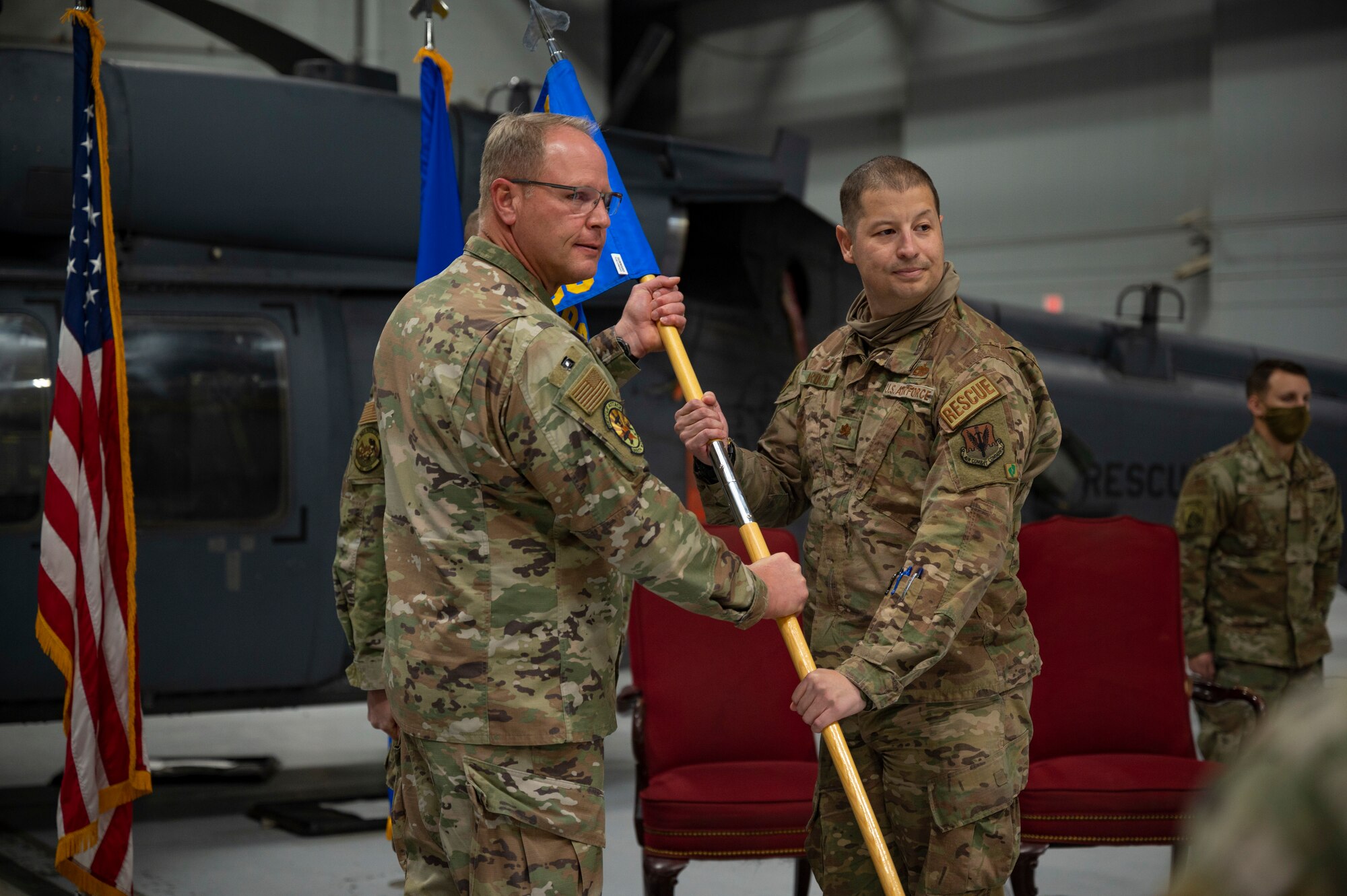 Two Airmen holding a guidon.