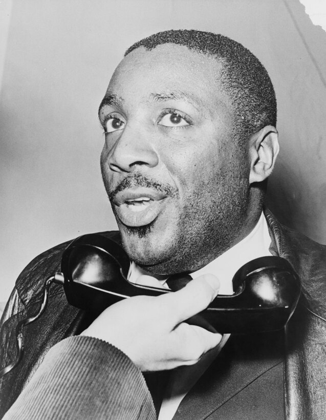 A man speaks as a phone is held to his mouth.