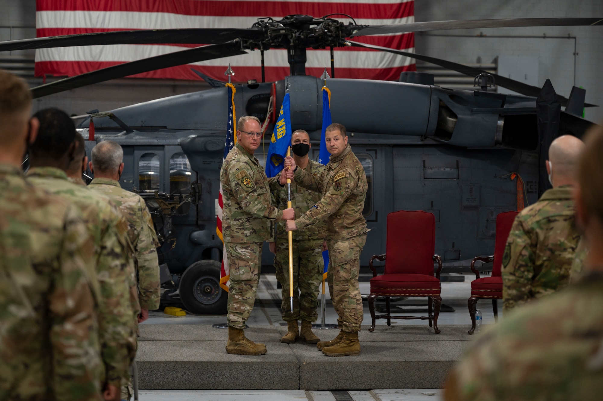 Two Airmen holding a flag.