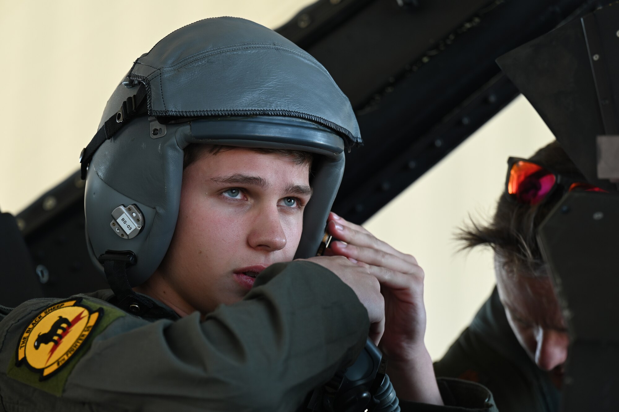 Brandon Burrow, U.S. Air Force Academy cadet, buckles his helmet before an F-16 Viper familiarization flight, Dec. 14, 2021, on Holloman Air Force Base, New Mexico. Burrow was one of three cadets chosen to participate in aircrew ground training and to receive a F-16 familiarization flight. (U.S. Air Force photo by Staff Sgt. Christopher S. Sparks)