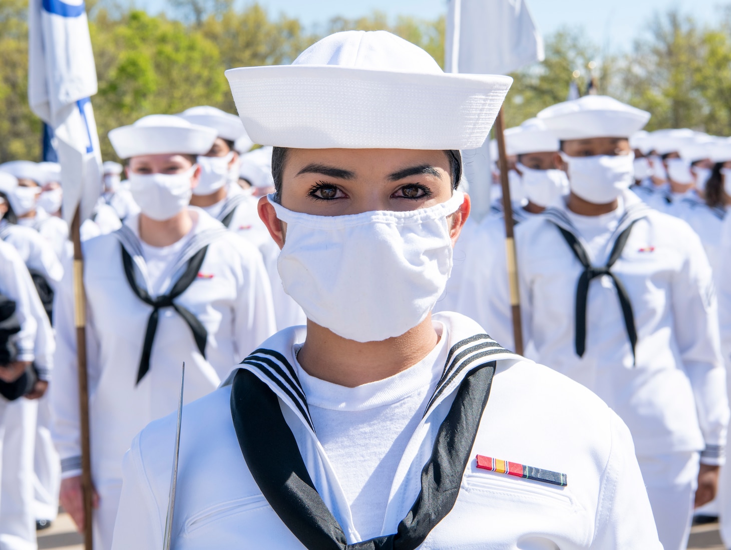 A recruit chief petty officer stands at the lead of her formation before their pass-in-review graduation ceremony at Recruit Training Command.