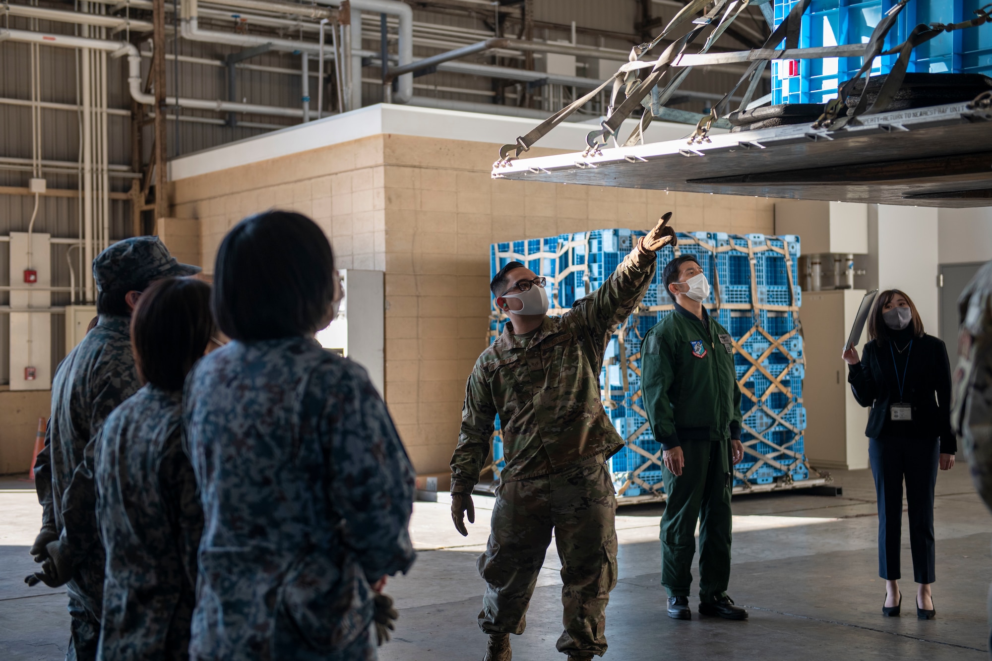 A U.S. Air Force Airman explains cargo pallet inspections to members of the Japan Air Self Defense Force