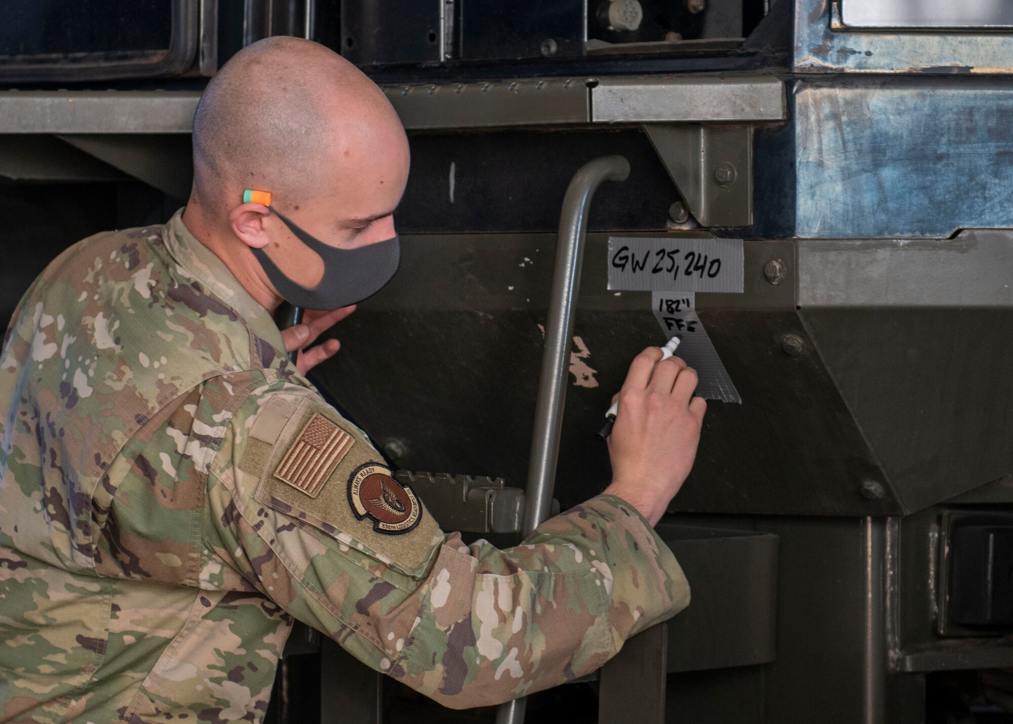 A U.S. Air Force Airman writes down the gross weight of the 10K All-Terrain Forklift on a piece of tape