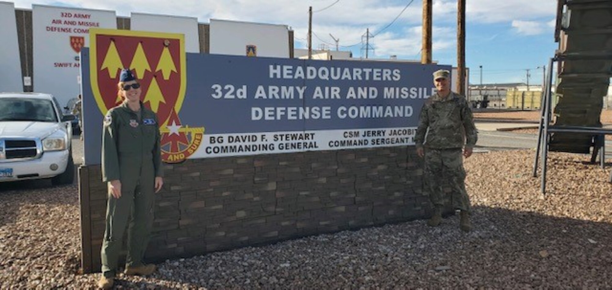 Photo of two U.S, military officials in front of 32d Army Air Missile Defense Command sign