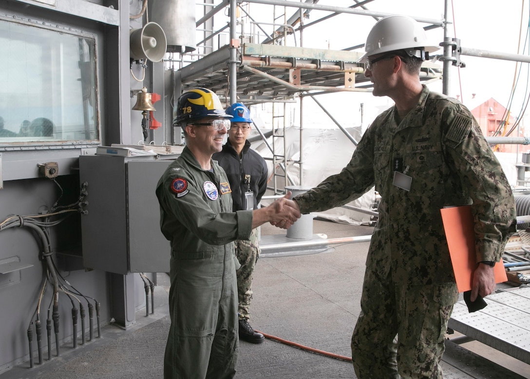 Vice Adm. Darse E. Crandall, Jr., Judge Advocate General (JAG) of the Navy, is greeted by Capt. Paul Lanzilotta, USS Gerald R. Ford's (CVN 78) commanding officer, during a ship visit, Dec. 17, 2021.