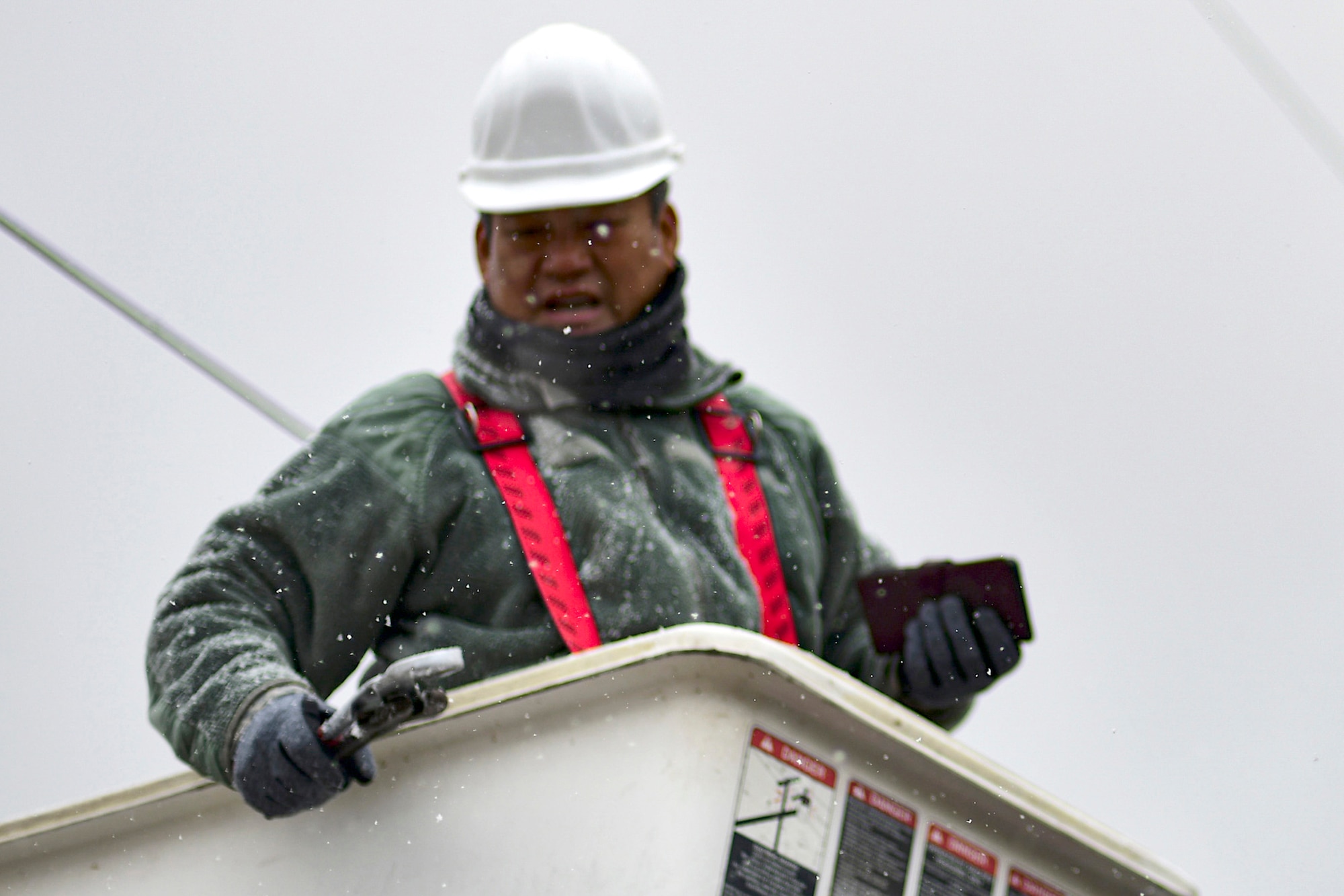 A technician stands in a bucket truck.