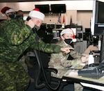 Capt. Kevin Vincent of the Royal Canadian Air Force, left, and Airman 1st Class Megan Mills of the New York Air National Guard’s 224th Air Defense Squadron, recently conducted training at the Eastern Air Defense Sector in Rome, N.Y., in preparation for NORAD Tracks Santa operations on Christmas Eve.