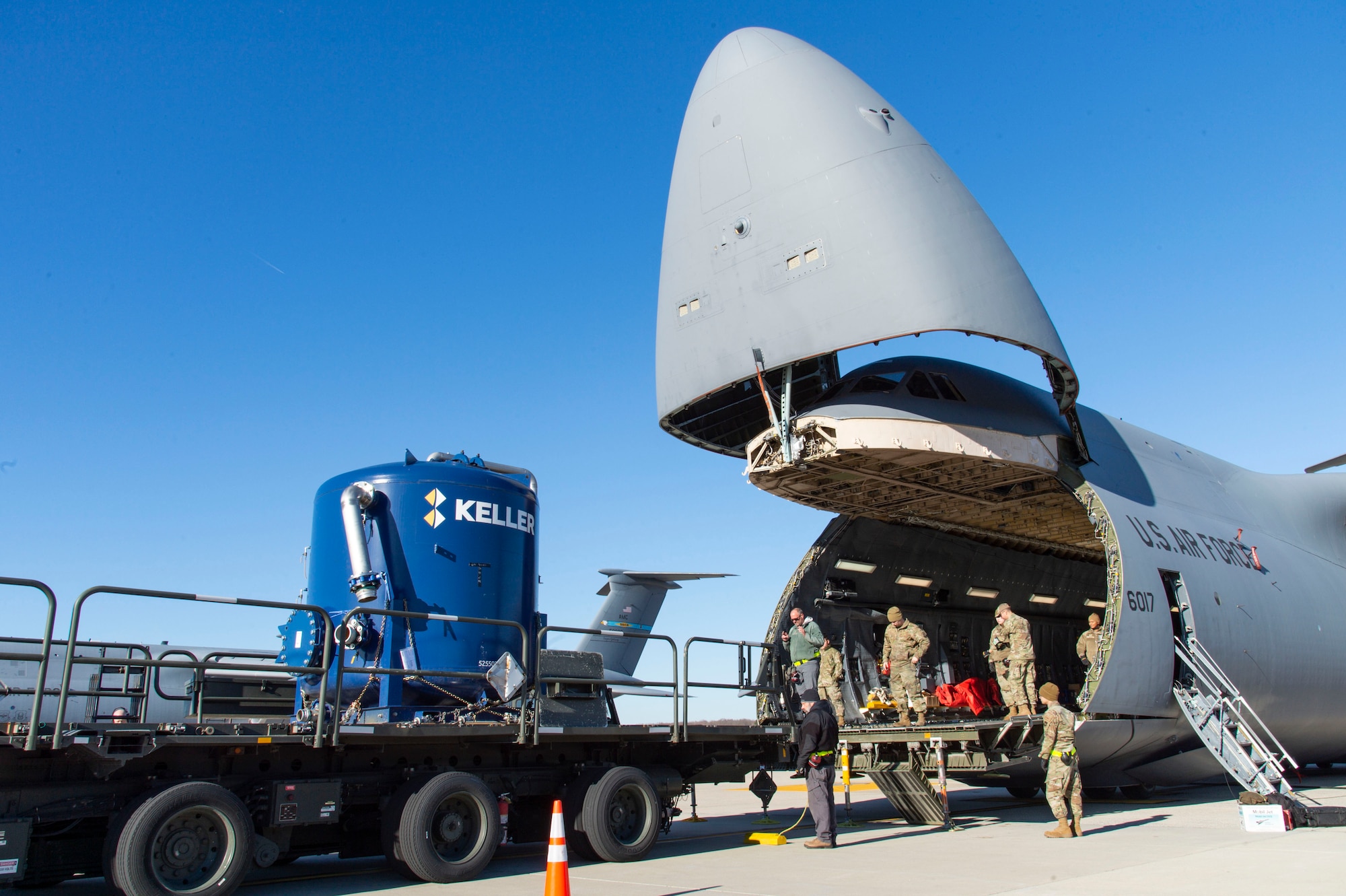 A 436th Aerial Port Squadron ramp services load team prepares to load water filtration equipment on a C-5M Super Galaxy at Dover Air Force Base, Delaware, Dec. 20, 2021. An aircrew from the 9th Airlift Squadron flew the equipment to Joint Base Pearl Harbor-Hickam (JBPHH), Hawaii. The JBPHH water quality recovery is a joint U.S. military initiative working closely with the State of Hawaii, Department of Health, Honolulu Board of Water Supply, U.S. government and independent organizations to restore a safe water delivery system to JBPHH military housing communities through testing, treatment, and repair. For detailed information, including available resources and locations, and news, go to www.navy.mil/jointbasewater. (U.S. Air Force photo by Roland Balik)