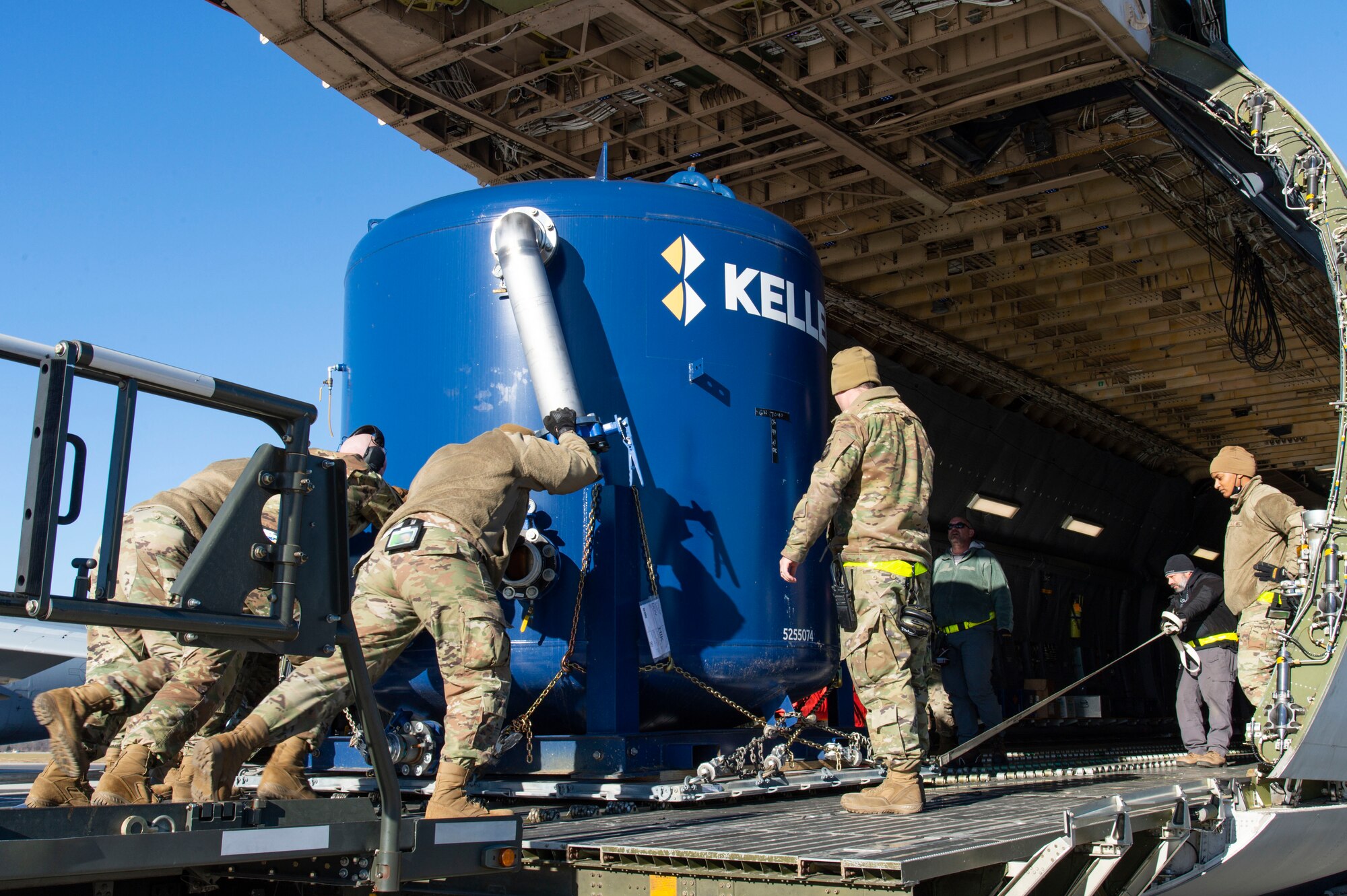 A 436th Aerial Port Squadron ramp services load team loads water filtration equipment on a C-5M Super Galaxy at Dover Air Force Base, Delaware, Dec. 20, 2021. An aircrew from the 9th Airlift Squadron flew the equipment to Joint Base Pearl Harbor-Hickam (JBPHH), Hawaii. The JBPHH water quality recovery is a joint U.S. military initiative working closely with the State of Hawaii, Department of Health, Honolulu Board of Water Supply, U.S. government and independent organizations to restore a safe water delivery system to JBPHH military housing communities through testing, treatment, and repair. For detailed information, including available resources and locations, and news, go to www.navy.mil/jointbasewater.  (U.S. Air Force photo by Roland Balik) (This photo has been altered for security purposes by blurring out identification badges.)