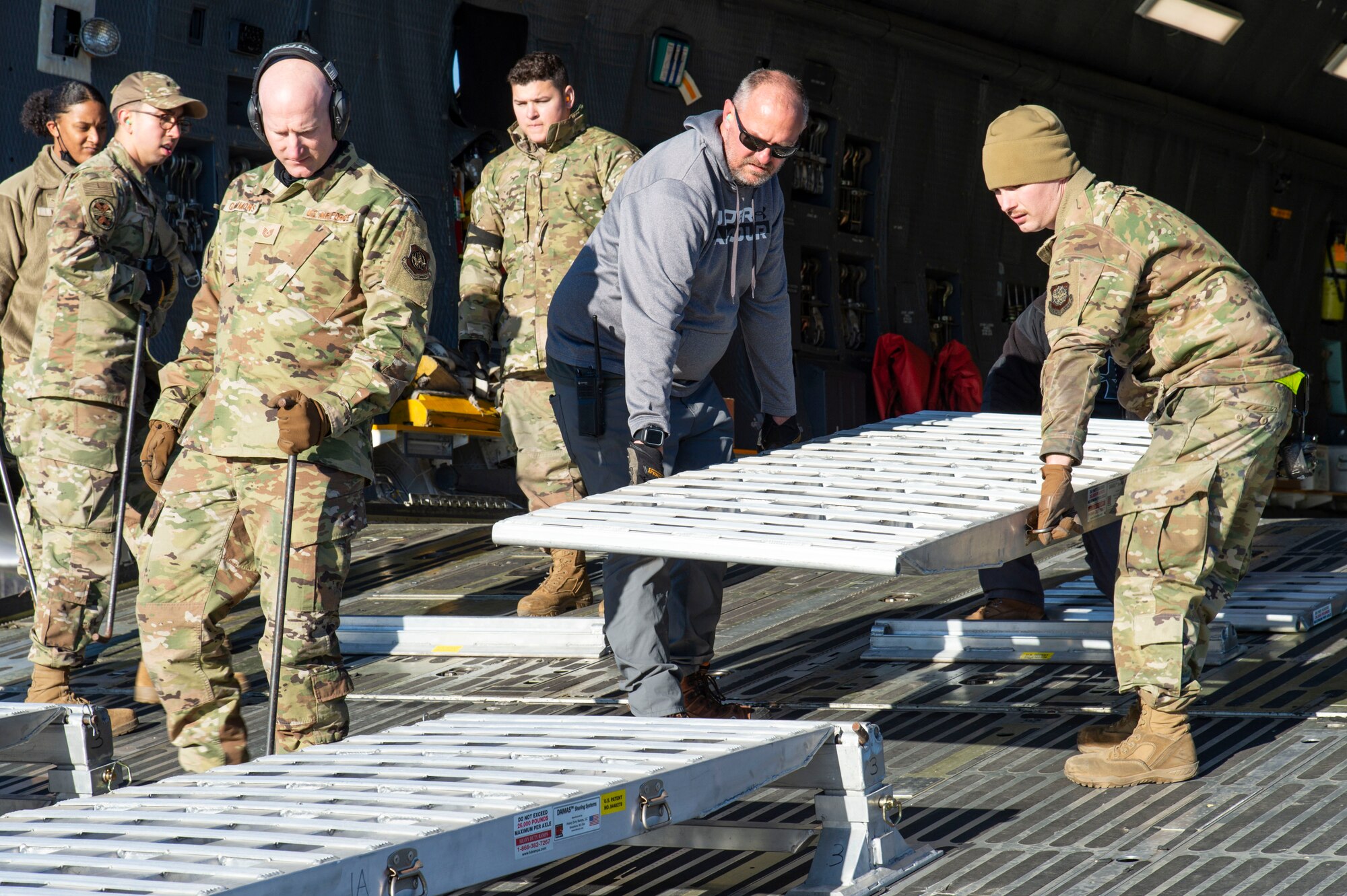 Ramp services personnel from the 436th Aerial Port Squadron place a modular ramp system in position to facilitate the loading of water filtration equipment onto a C-5M Super Galaxy at Dover Air Force Base, Delaware, Dec. 20, 2021. An aircrew from the 9th Airlift Squadron flew the equipment to Joint Base Pearl Harbor-Hickam (JBPHH), Hawaii. The JBPHH water quality recovery is a joint U.S. military initiative working closely with the State of Hawaii, Department of Health, Honolulu Board of Water Supply, U.S. government and independent organizations to restore a safe water delivery system to JBPHH military housing communities through testing, treatment, and repair. For detailed information, including available resources and locations, and news, go to www.navy.mil/jointbasewater. (U.S. Air Force photo by Roland Balik)