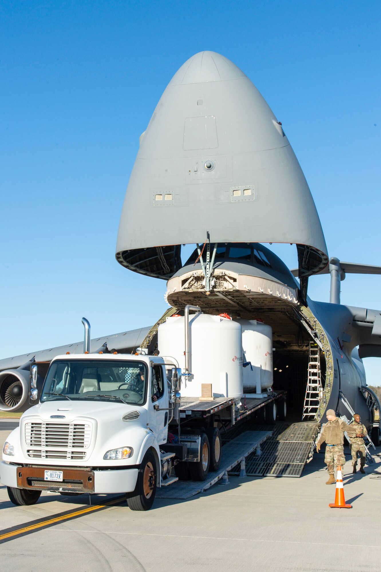 Tony Forcier, 436th Aerial Port Squadron ramp services foreman, backs up a trailer loaded with water filtration equipment onto a C-5M Super Galaxy at Dover Air Force Base, Delaware, Dec. 20, 2021. An aircrew from the 9th Airlift Squadron flew the equipment to Joint Base Pearl Harbor-Hickam (JBPHH), Hawaii. The JBPHH water quality recovery is a joint U.S. military initiative working closely with the State of Hawaii, Department of Health, Honolulu Board of Water Supply, U.S. government and independent organizations to restore a safe water delivery system to JBPHH military housing communities through testing, treatment, and repair. For detailed information, including available resources and locations, and news, go to www.navy.mil/jointbasewater.   (U.S. Air Force photo by Roland Balik)