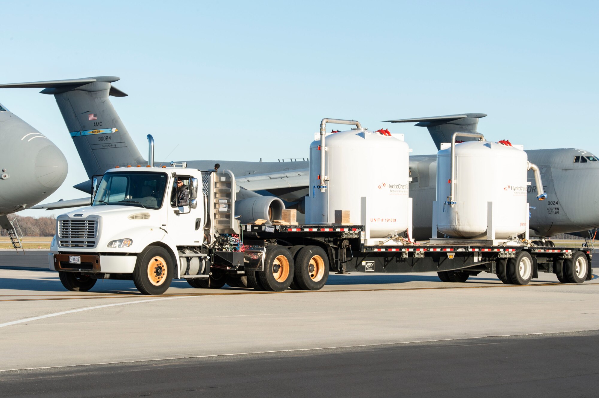 Tony Forcier, 436th Aerial Port Squadron ramp services foreman, drives a trailer loaded with water filtration equipment on the flight line at Dover Air Force Base, Delaware, Dec. 20, 2021. A C-5M Super Galaxy aircrew assigned to the 9th Airlift Squadron, flew the equipment to Joint Base Pearl Harbor-Hickam (JBPHH), Hawaii. The JBPHH water quality recovery is a joint U.S. military initiative working closely with the State of Hawaii, Department of Health, Honolulu Board of Water Supply, U.S. government and independent organizations to restore a safe water delivery system to JBPHH military housing communities through testing, treatment, and repair. For detailed information, including available resources and locations, and news, go to www.navy.mil/jointbasewater. (U.S. Air Force photo by Roland Balik)