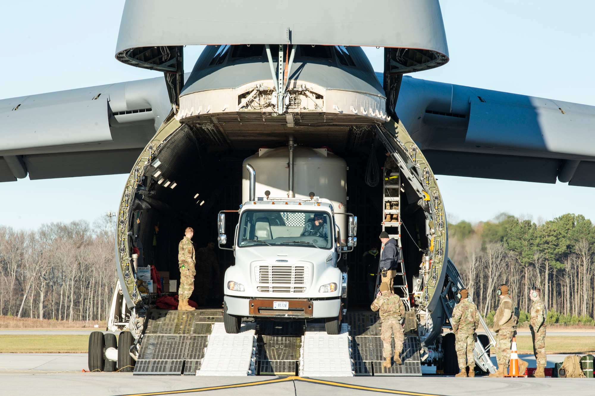 Tony Forcier, 436th Aerial Port Squadron ramp services foreman, backs up a trailer loaded with water filtration equipment onto a C-5M Super Galaxy at Dover Air Force Base, Delaware, Dec. 20, 2021. An aircrew from the 9th Airlift Squadron flew the equipment to Joint Base Pearl Harbor-Hickam (JBPHH), Hawaii. The JBPHH water quality recovery is a joint U.S. military initiative working closely with the State of Hawaii, Department of Health, Honolulu Board of Water Supply, U.S. government and independent organizations to restore a safe water delivery system to JBPHH military housing communities through testing, treatment, and repair. For detailed information, including available resources and locations, and news, go to www.navy.mil/jointbasewater.  (U.S. Air Force photo by Roland Balik)