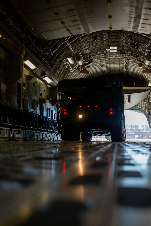 U.S. Marines with 2d Battalion, 10th Marine Regiment (2/10), 2d Marine Division, and U.S. Airmen with 16th Airlift Squadron load a medium tactical vehicle replacement onto a C-17 Globemaster III at Marine Corps Air Station Cherry Point, N.C., Dec. 16, 2021.