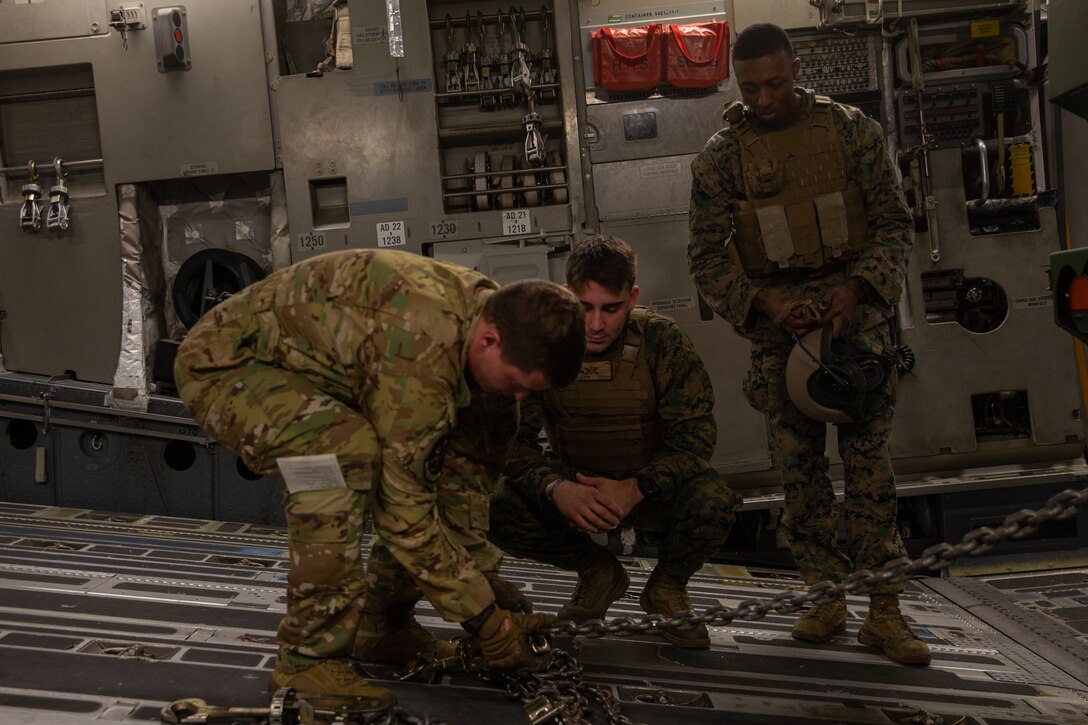 A U.S. Airman with 16th Airlift Squadron, left, and U.S. Marines with 2d Battalion, 10th Marine Regiment (2/10), 2d Marine Division, secure a high mobility artillery rocket system to a C-17 Globemaster III at Marine Corps Air Station Cherry Point, N.C., Dec. 16, 2021. Marines with 2/10 integrated with the squadron to gain proficiency in transporting tactical vehicles. (U.S. Marine Corps photo by Lance Cpl. Reine Whitaker)