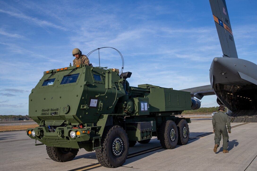 U.S. Marines with 2d Battalion, 10th Marine Regiment (2/10), 2d Marine Division, off load a high mobility artillery rocket system from a C-17 Globemaster III at Marine Corps Air Station Cherry Point, N.C., Dec. 16, 2021. Marines with 2/10 integrated with the squadron to gain proficiency in transporting tactical vehicles. (U.S. Marine Corps photo by Lance Cpl. Reine Whitaker)