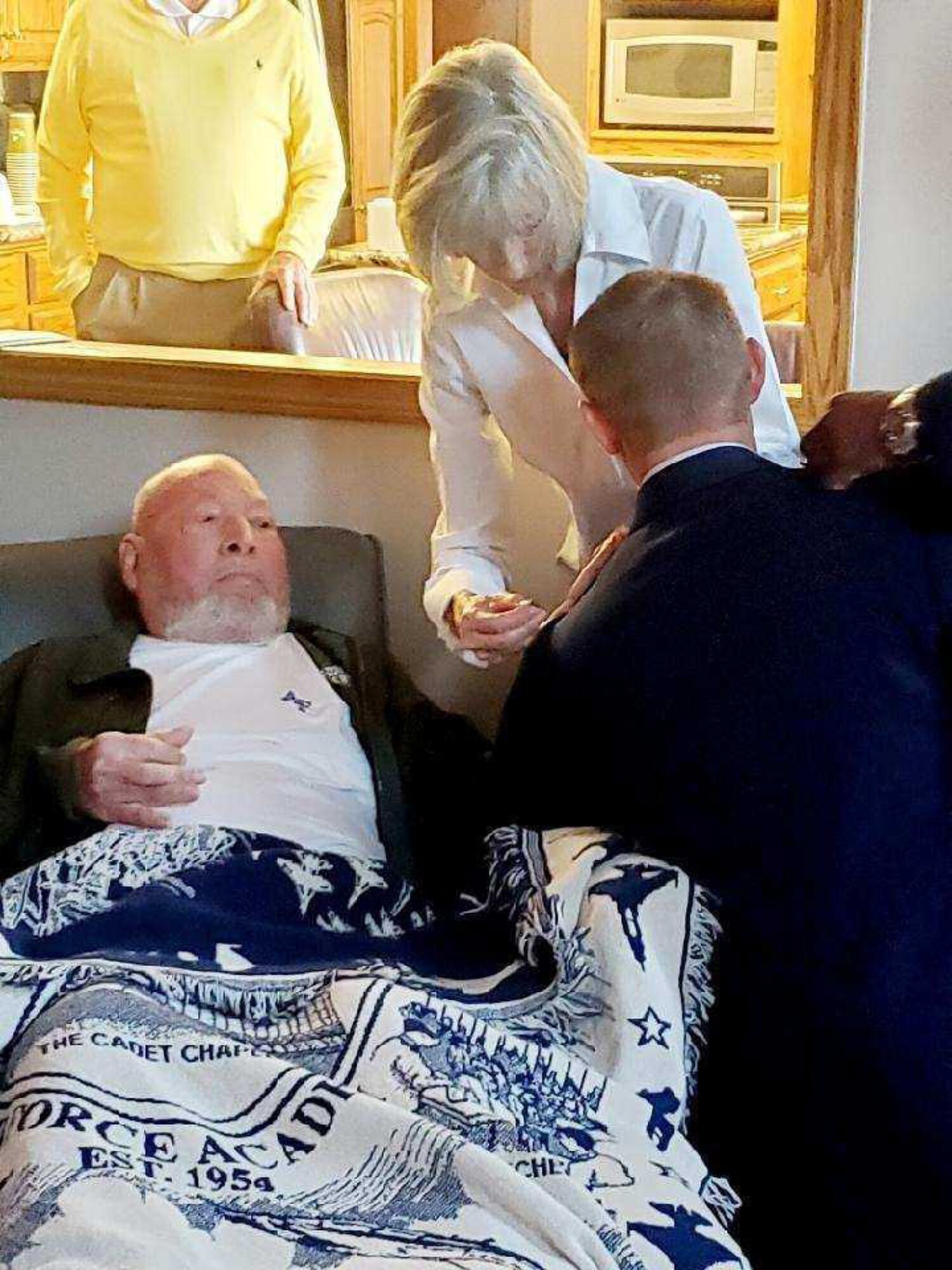 Don Deckert, father of Maj. Travis Deckert, helps add the new rank to his son's uniform during a promotion ceremony.
