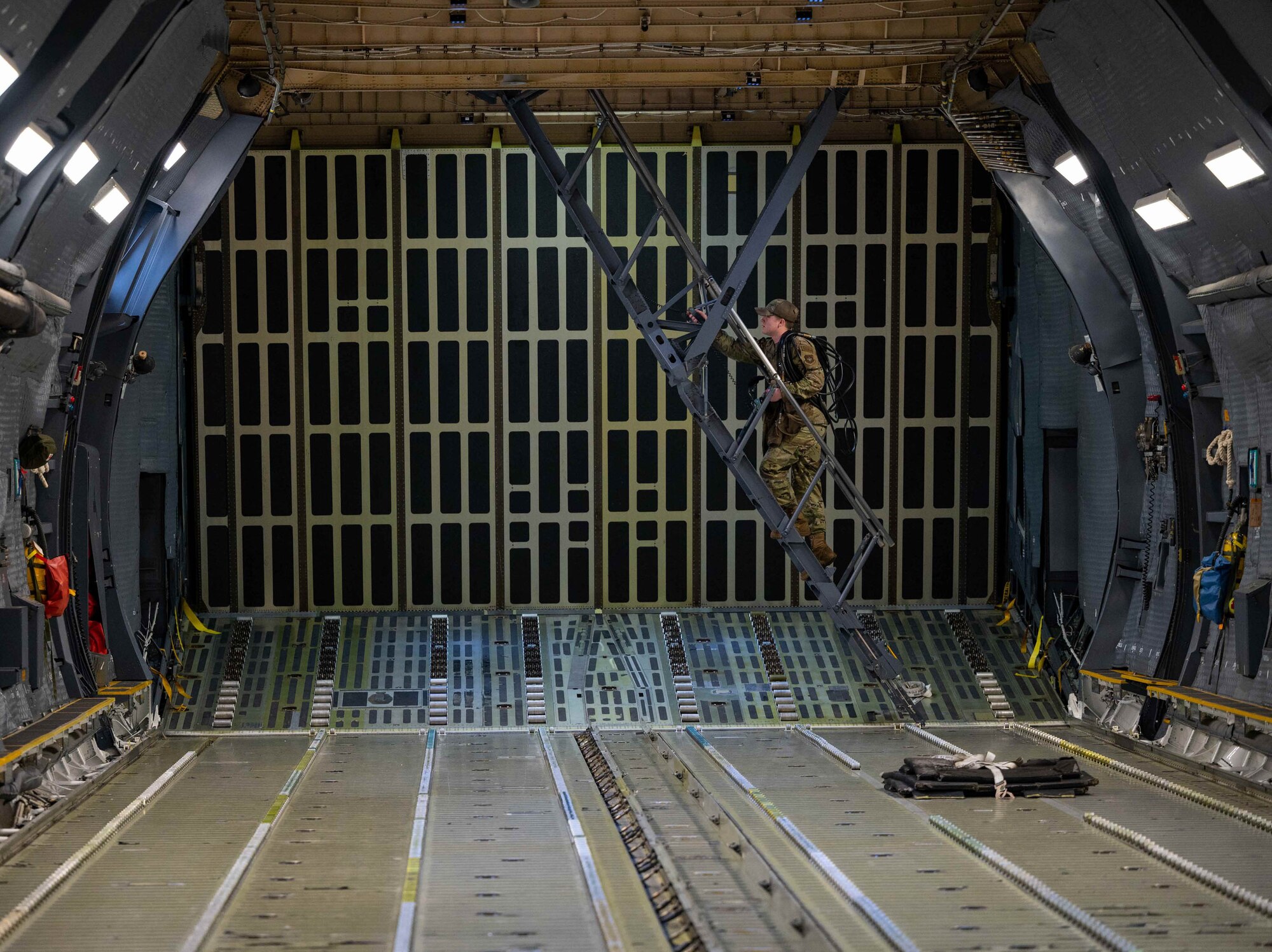 Airman 1st Class Liam Neven, 436th Aircraft Maintenance Squadron crew chief, climbs stairs towards the troop compartment on a C-5M Super Galaxy before takeoff to Joint Base McGuire-Dix-Lakehurst, New Jersey, at Dover Air Force Base, Delaware, Dec. 17, 2021. The 9th Airlift Squadron delivered supplies to aid the Joint Base Pearl Harbor-Hickam (JBPHH), Hawaii water quality recovery, a joint U.S. military initiative working closely with the State of Hawaii, Department of Health, Honolulu Board of Water Supply, U.S. government and independent organizations to restore a safe water delivery system to JBPHH military housing communities through testing, treatment, and repair. For detailed information, including available resources and locations, and news, go to www.navy.mil/jointbasewater.      (U.S. Air Force photo by Senior Airman Faith Schaefer)