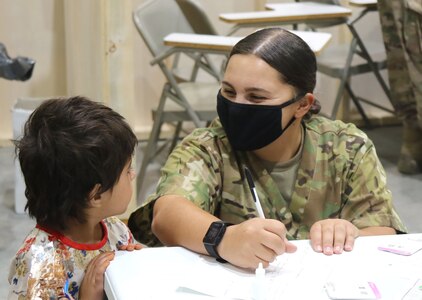 A U.S. Army National Guard Soldier assigned to Task Force Spartan, U.S. Army Central, assists an Afghan evacuee with a medical screening as one of the first steps in his arrival at Camp Buehring, Kuwait, Aug. 25, 2021. USARCENT Soldiers from all components continue to work with their U.S. Central Command and Department of State teammates to support Afghanistan evacuation efforts with transportation, security, logistics and medical assistance at locations in Kuwait.